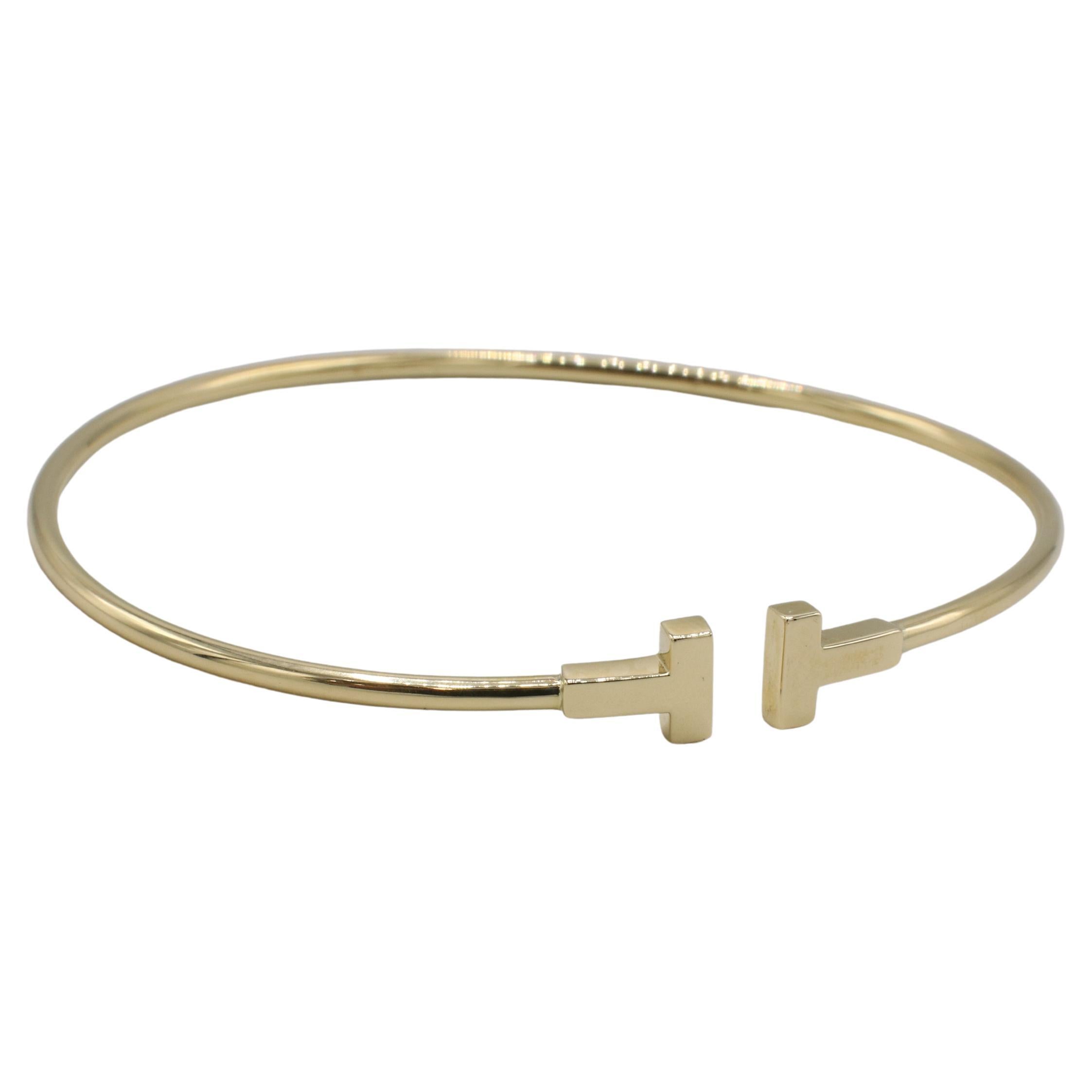 Tiffany & Co. T. Narrow Wire 18 Karat Yellow Gold Bangle Bracelet 
Metal: 18k yellow gold
Weight: 3.55 grams
Size: Fits up to a 6.75 inch wrist
Retail: $2,050 USD
NDD F35000068

