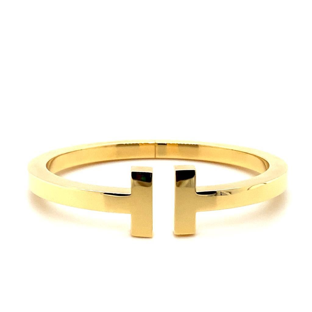 A Tiffany & Co. ‘'T' square bracelet in 18 karat yellow gold.

From Tiffany & Co's current 'T' collection this bracelet features two facing 'T's in a squared design with a plain polished finish in 18 karat yellow gold and can be opened via its