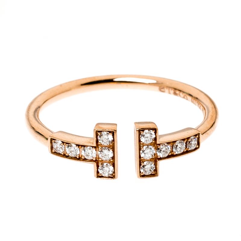 Coming from the house of Tiffany & Co., this ring boasts of a sleek and simple silhouette. Crafted in an 18k rose gold body, this beautiful ring features an open-top style with a diamond embedded 'T' on both the openings. It arrives in a Tiffany &