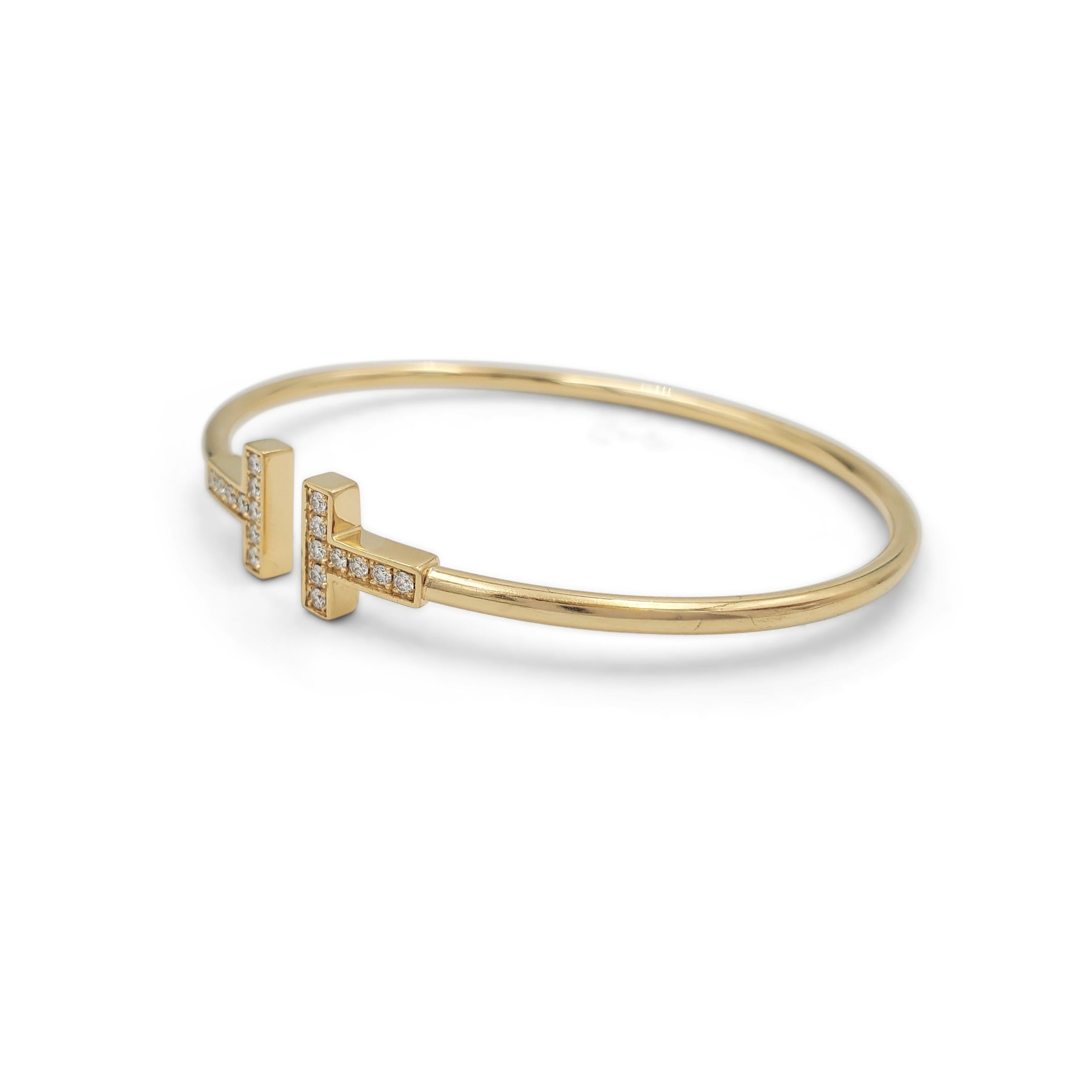 Authentic Tiffany & Co. T Square Wire bracelet made in 18 karat yellow gold with approximately 18 diamonds weighing an estimated .18 carats. Can fit up to a size 6 1/4 wrist.  Inspired by the strong, clean lines of the letter T, this bracelet is