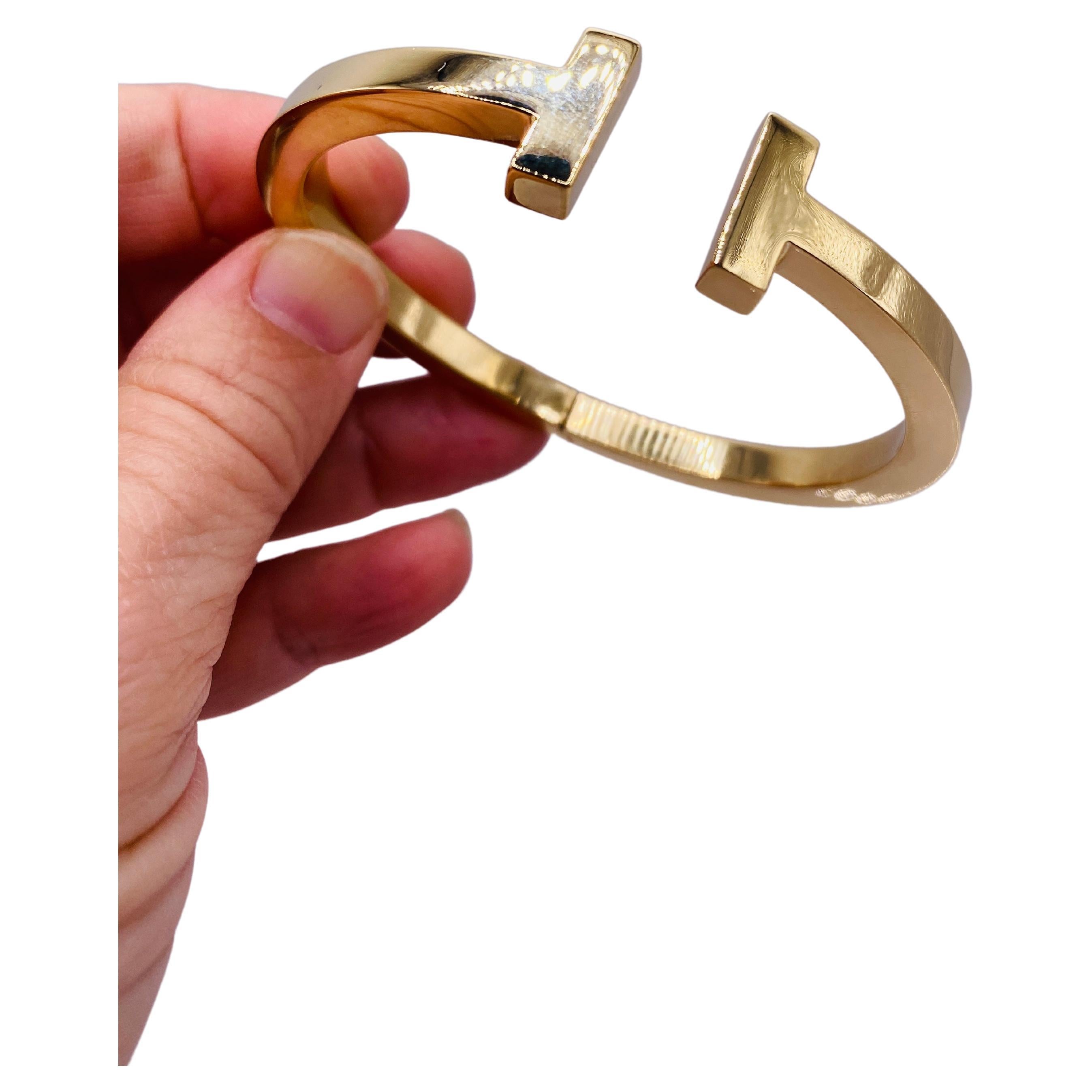 Tiffany & Co 18k yellow gold T Collection hinged bangle bracelet. Approx. 2.24 inches inner diameter. Wrist size in video is 6.25 inches. 17.7Dwt. MSRP $6,300. Product No. 60010736