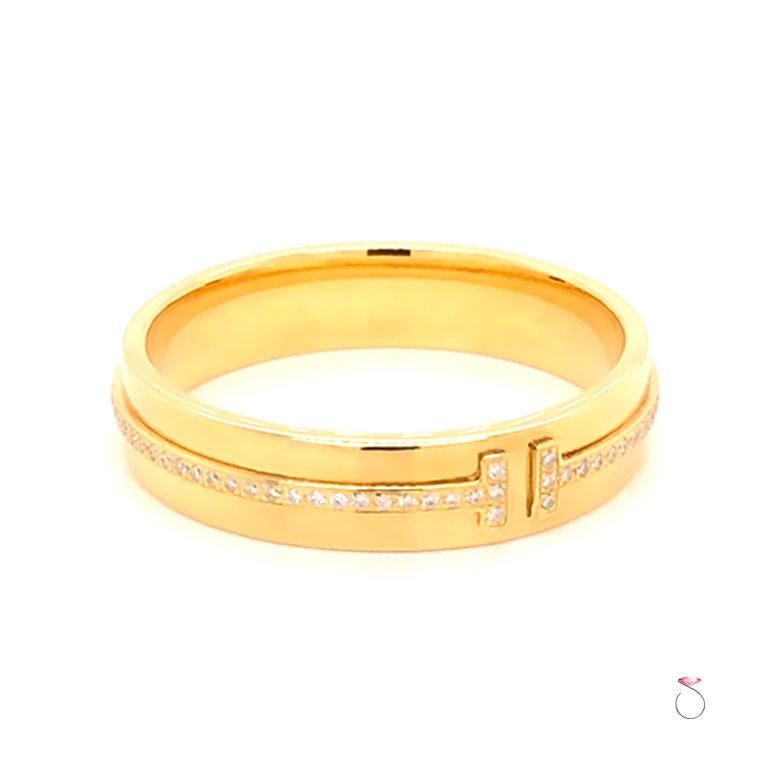 Authentic Tiffany & Co. T Wide Diamond Band Ring, 18K Yellow Gold. This striking ring features a bold 