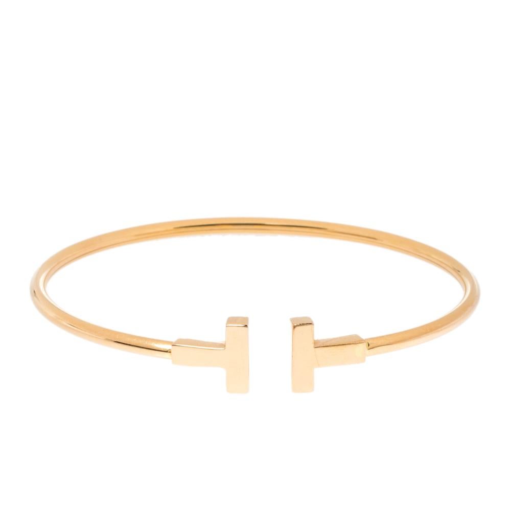 The Tiffany T collection by Tiffany & Co. is a celebrated jewelry line. Each piece comes with a distinct shape that boasts of fabulous style and structure. This T Wire is crafted from 18K rose gold and styled as a wire-like band with the letter T on