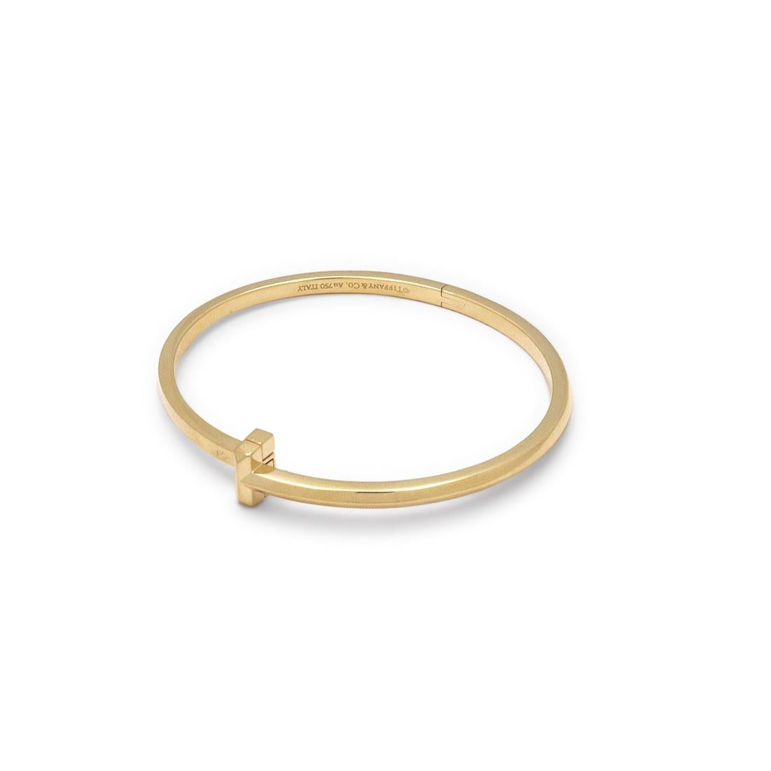 Authentic Tiffany & Co. ' T1 Narrow Hinged' bangle crafted in 18 karat yellow gold. This stunning bangle features a bold 
