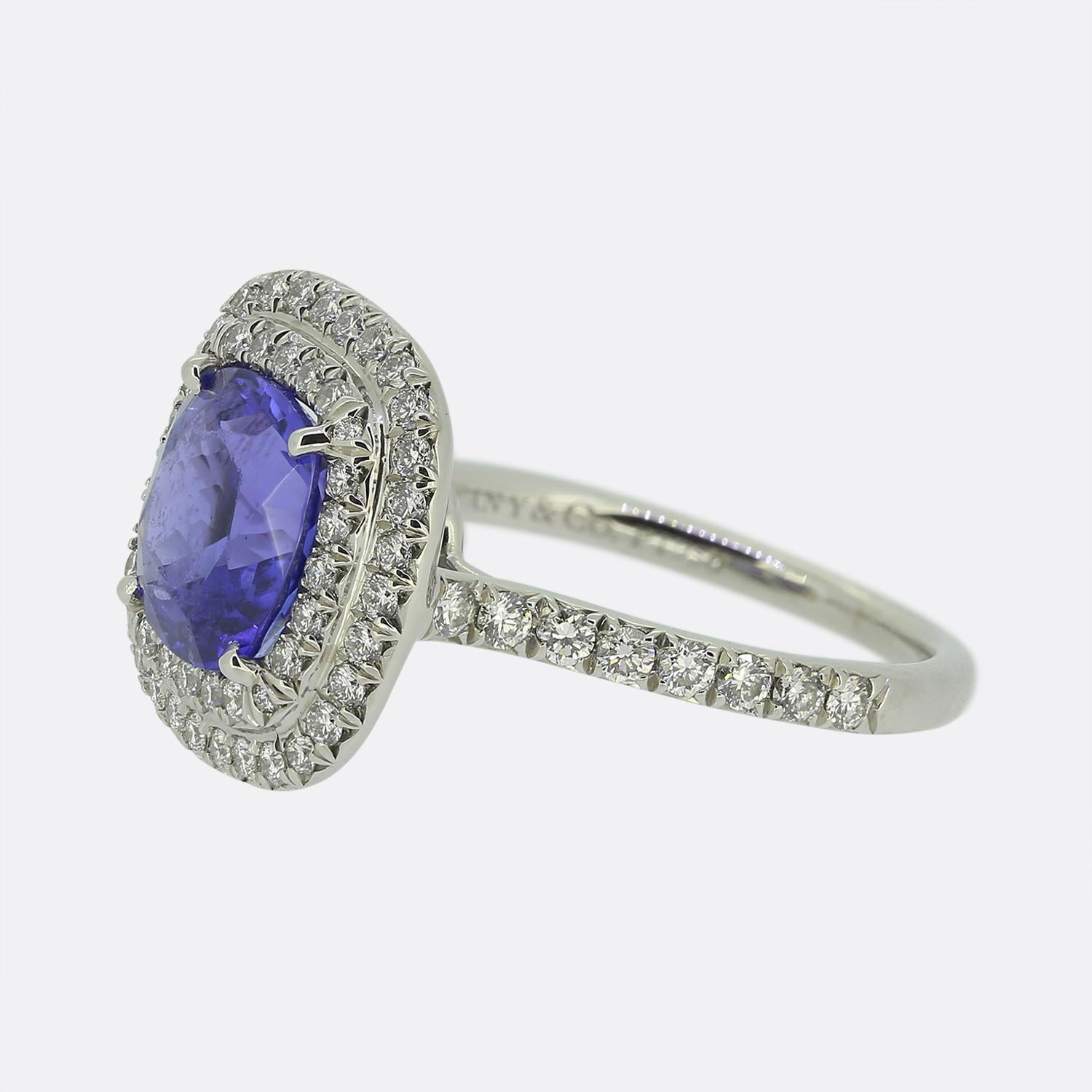 This is a wonderful Tiffany & Co. tanzanite and diamond ring from their iconic Soleste collection. The central tanzanite is a vivid purple Blue and is highly complimented by the contrasting bright white sparkle of the round brilliant cut diamonds.