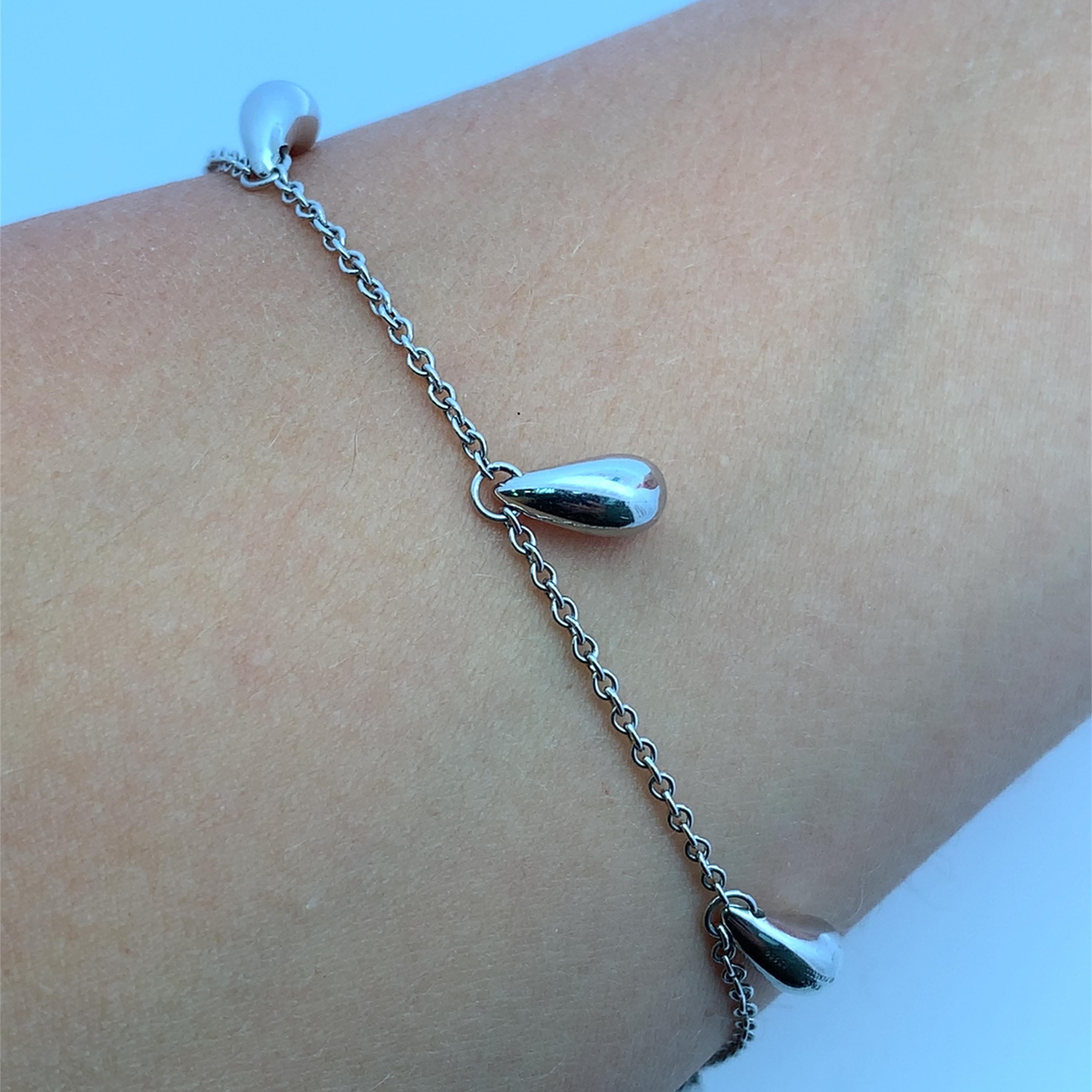 Élevez votre style avec ce chic bracelet à chaîne Tiffany&Co vintage en platine. Cette pièce délicate présente des charmes fantaisistes en forme de goutte d'eau, ajoutant une touche d'élégance contemporaine à n'importe quel ensemble. Parfait pour le