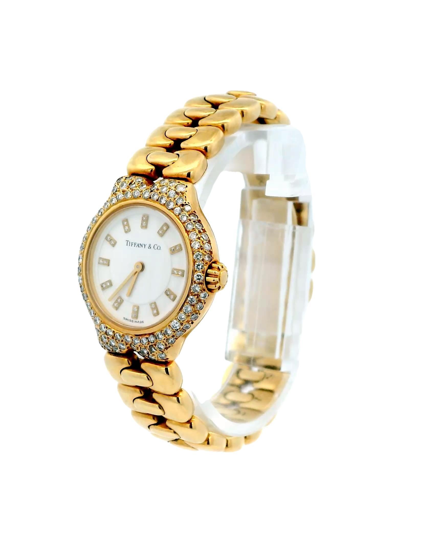 Una lujosa caja de Tiffany & Co. Tessoro
Reloj de cuarzo redondo de oro de 18 quilates con marcadores y bisel de diamantes. Fabricación suiza.

Peso total: 73.6 g
Longitud: 15.0 cm