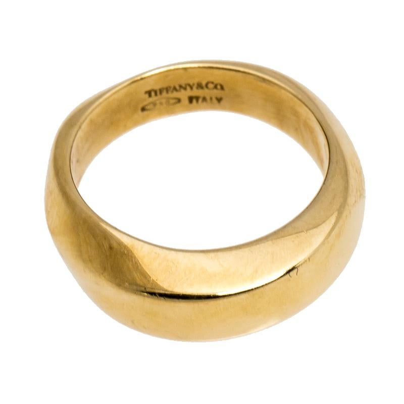 This Tiffany & Co. ring comes in precious 18k yellow gold and boasts of a luxurious yet simplistic design approach. The wide band displays the signature brand engravings while a pattern of raised textures on the surface gives it an exquisite