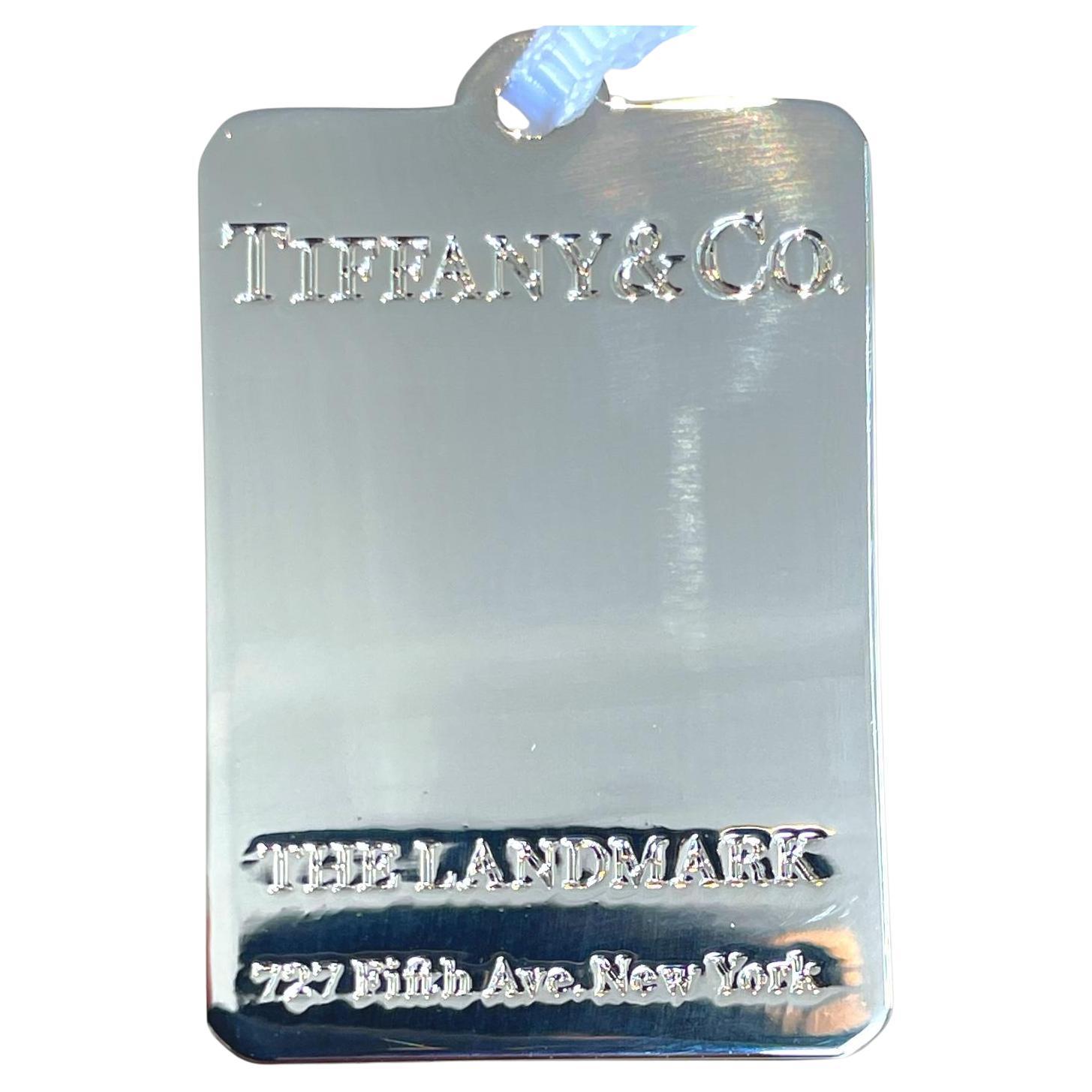 Eleva il tuo arredamento natalizio con l'edizione limitata di Tiffany & Co. Tag Charm in tonalità argento, uno splendido ornamento natalizio che incarna eleganza e raffinatezza. Realizzato con una lucentezza a specchio, questo squisito pezzo