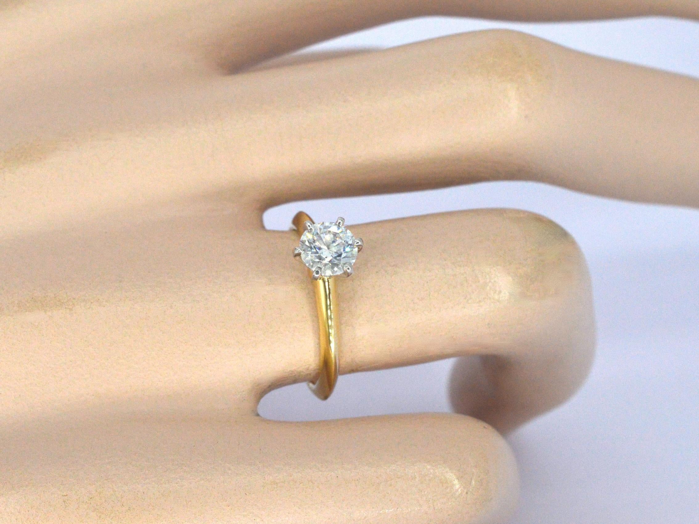 Einführung der kultigen Tiffany & Co. Der Tiffany-Fassungsring, ein zeitloses Symbol für Eleganz und Luxus. Dieser exquisite Ring besteht aus einem einzelnen Diamanten im Brillantschliff mit einem Gewicht von 0,74 Karat, der mit seiner