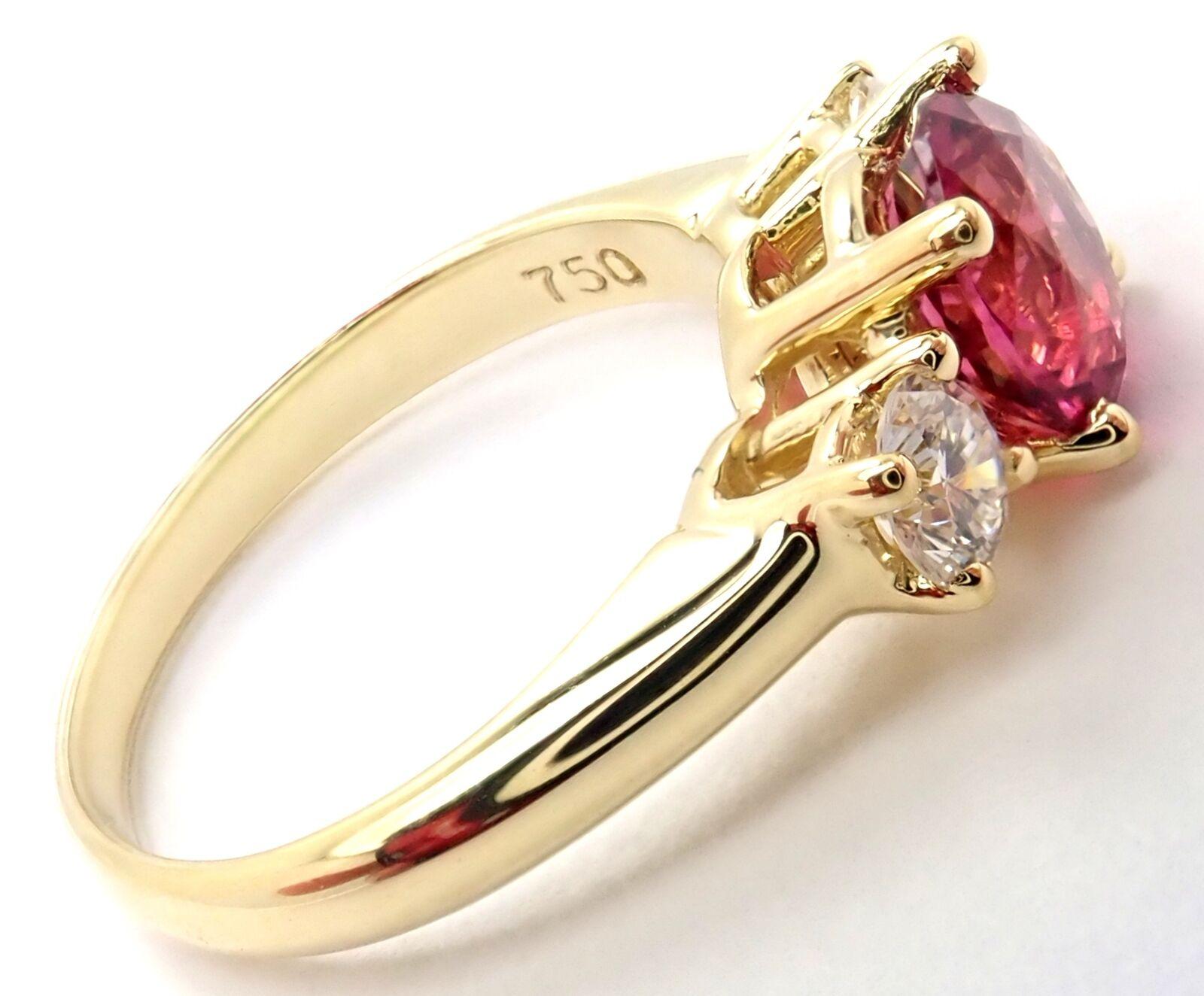 18k Yellow Gold Diamond And Pink Tourmaline Three Stone Band Ring by Tiffany & Co. 
With 2 Round Brilliant Cut Diamonds VS1 clarity, G color, Total weight Approximately .30ct
1 Round pink tourmaline 7mm total weight approximately 1.2ct
Details:
Ring