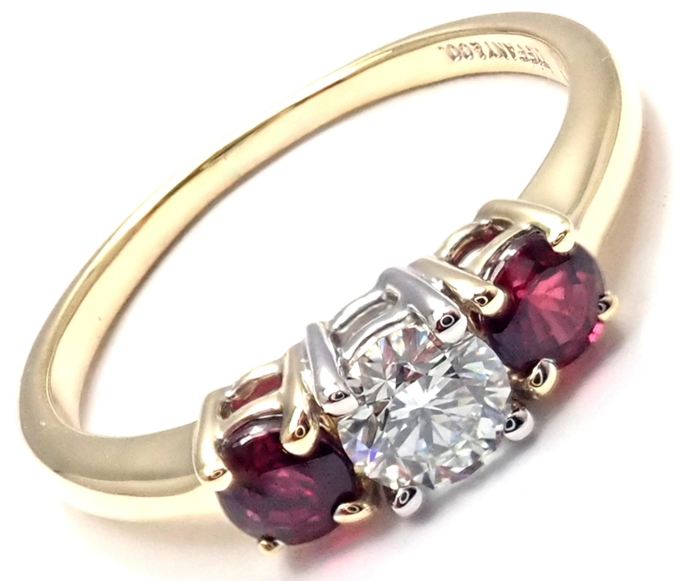 18k Yellow Gold and Platinum Diamond And Ruby Three Stone Band Ring by Tiffany & Co. 
With 1 Round Brilliant Cut Diamond VS1 clarity, G color, Total weight Approx .50ctw
2 Round rubies total weight approx.  0.50ct
Details:
Ring Size: 6
Width: