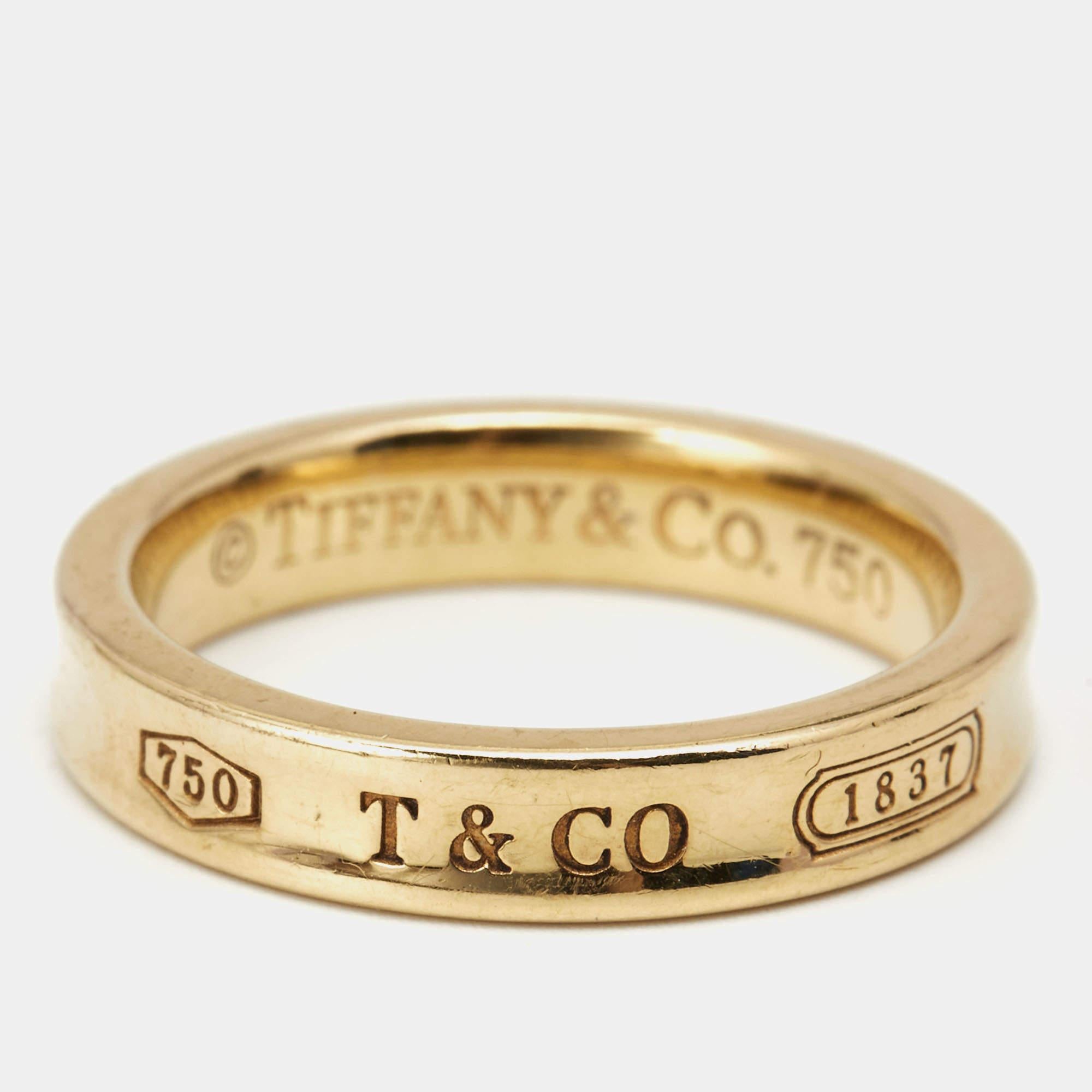 We'd love this Tiffany & Co. piece to complement our everyday style. The ring is made of 18k yellow gold and inscribed with logo details, and 1837—the year the brand was founded. It has a smooth finish and a comfortable fit.

Includes: Original