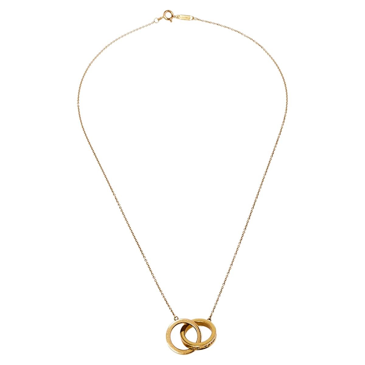 We can't help admiring this beauty from Tiffany & Co.! Beautifully crafted from 18k yellow gold, this necklace is a stunner. It has been gloriously styled with a pendant of interlocking rings. The pendant, inscribed with 1837, which is the year the