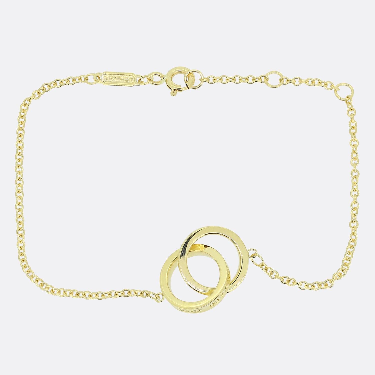 Here we have an 18ct yellow gold bracelet from the world renowned luxury jewellery designer, Tiffany & Co. A slim signed belcher chan plays host to a duo of matching rings sporting the iconic 'T&Co' initials and the founding year of '1837'.