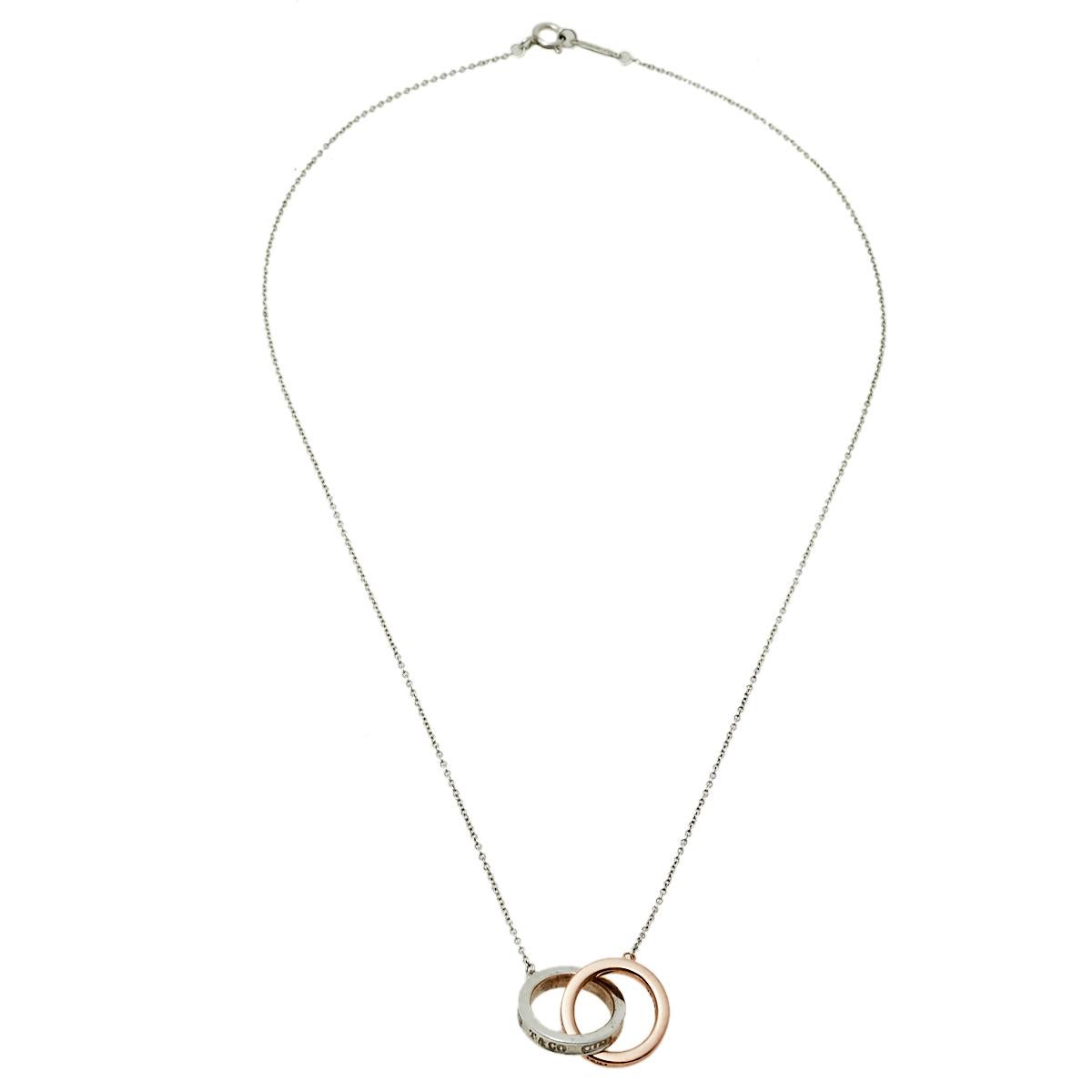 We can't help admiring this beauty from Tiffany & Co.! Beautifully crafted from silver, this necklace is a stunner. It has been gloriously styled with a pendant of interlocking rings, one made from silver and the other from rubedo. The pendant,
