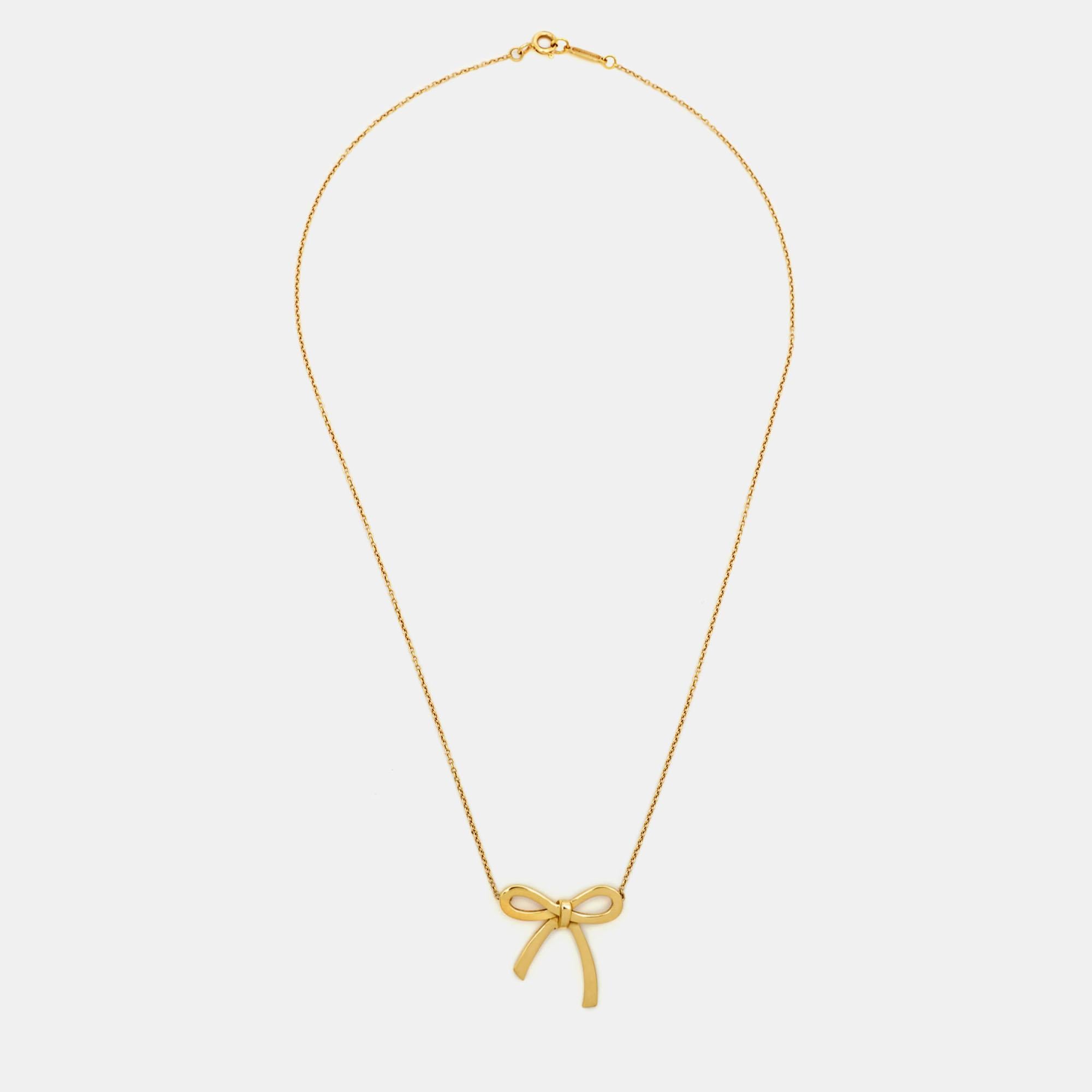 The Tiffany & Co. necklace is an exquisite piece of jewelry that combines elegance and sophistication. Crafted from luxurious 18k yellow gold, the necklace features a delicate bow pendant, symbolizing femininity and grace. This timeless accessory