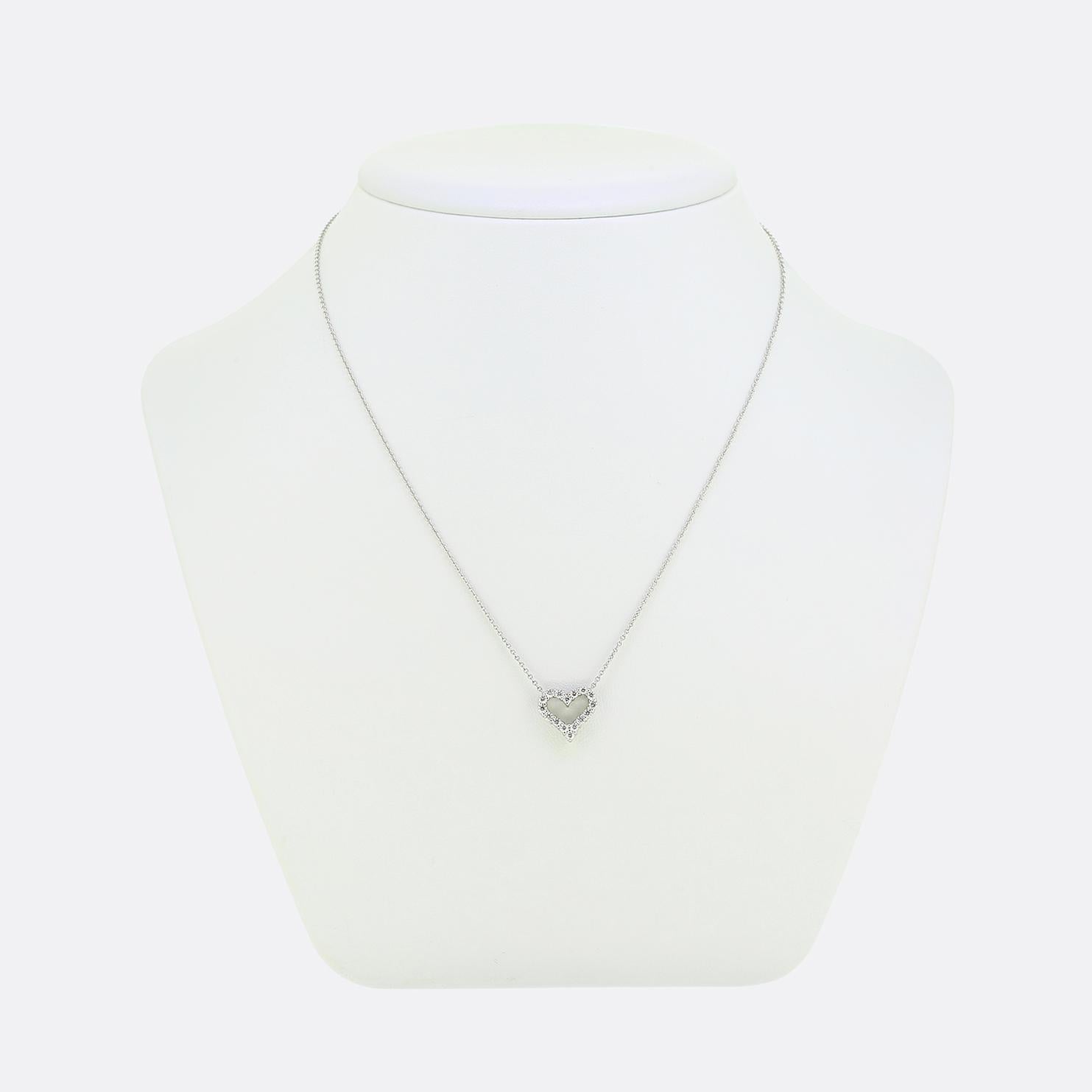 Aquí tenemos un romántico collar del mundialmente conocido diseñador de joyas Tiffany & Co. El colgante tiene la forma de un corazón de amor abierto y está adornado con una hilera de brillantes diamantes redondos blancos, que crean un deslumbrante