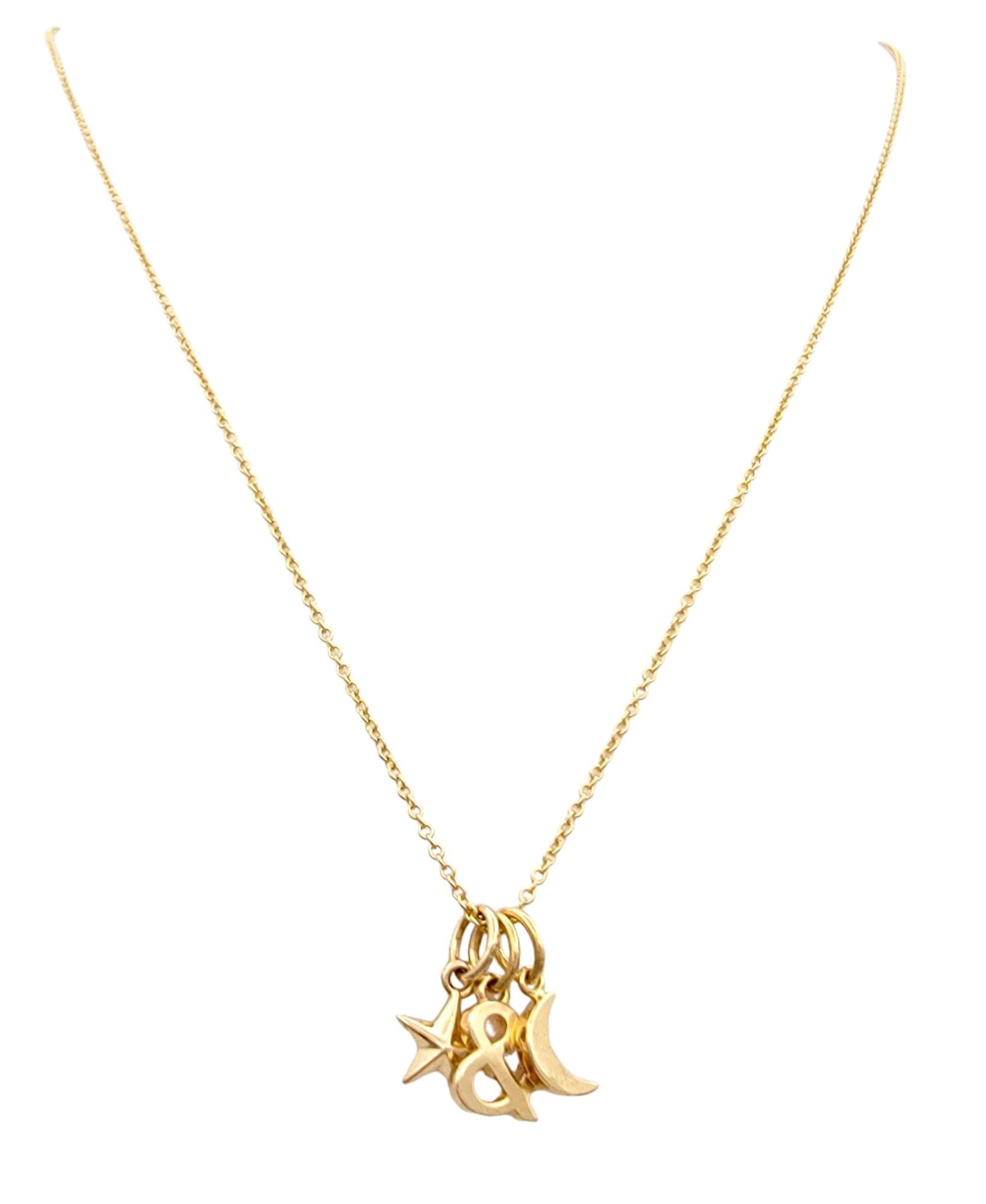 This beautiful Tiffany & Co. charm necklace in 18 karat rose gold is a delicate and whimsical piece that captures the magic of the night sky. Suspended from a dainty cable chain, the necklace features three charming pendants: a star, a moon, and an
