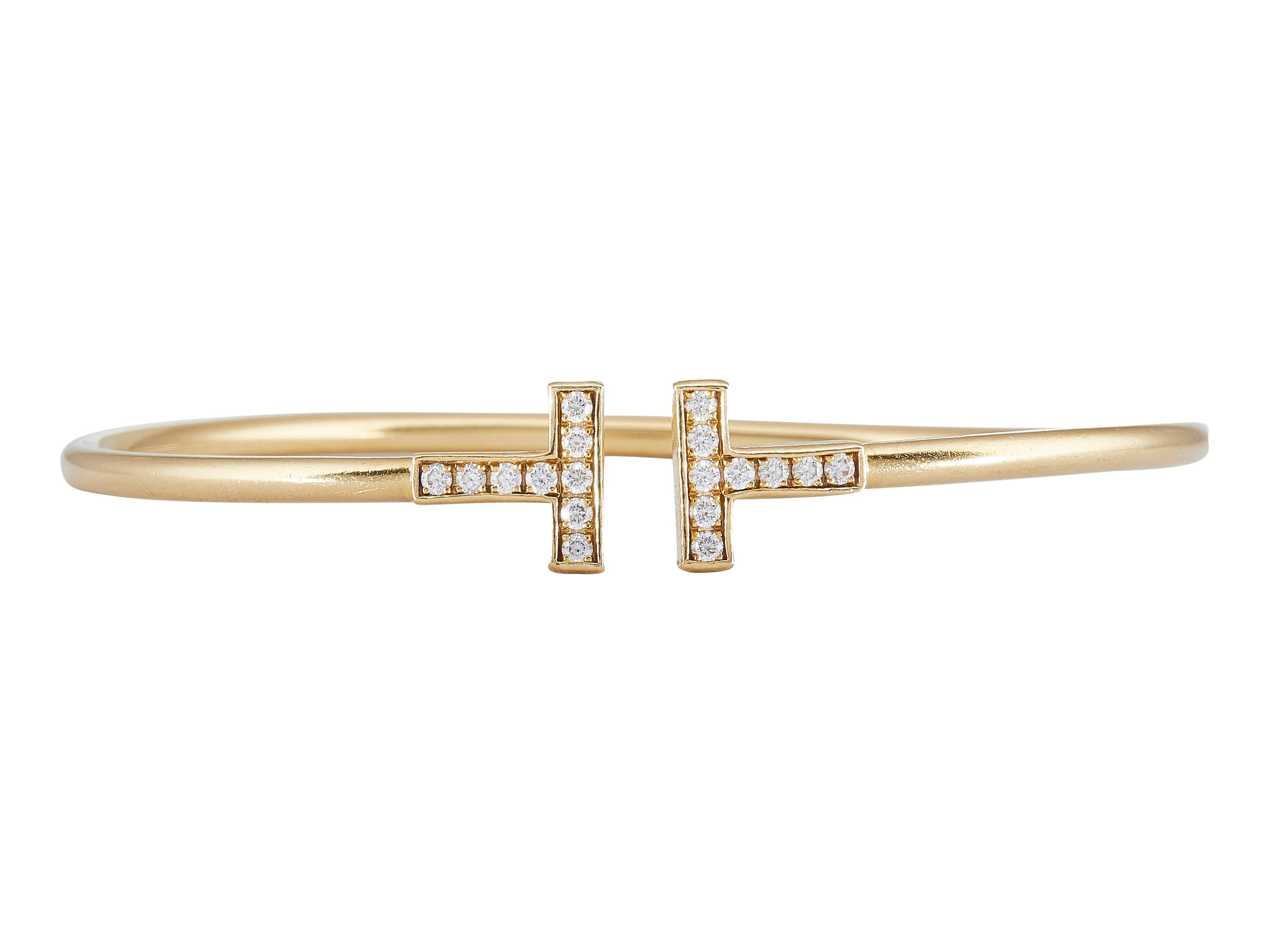 The bracelet:
A Tiffany & Co. Tiffany T eighteen karat yellow gold diamond wire bracelet in size medium.

The bracelet is in excellent condition, with only a few minor scratches that are expected with normal wear. 

Accompanied by...
It's original