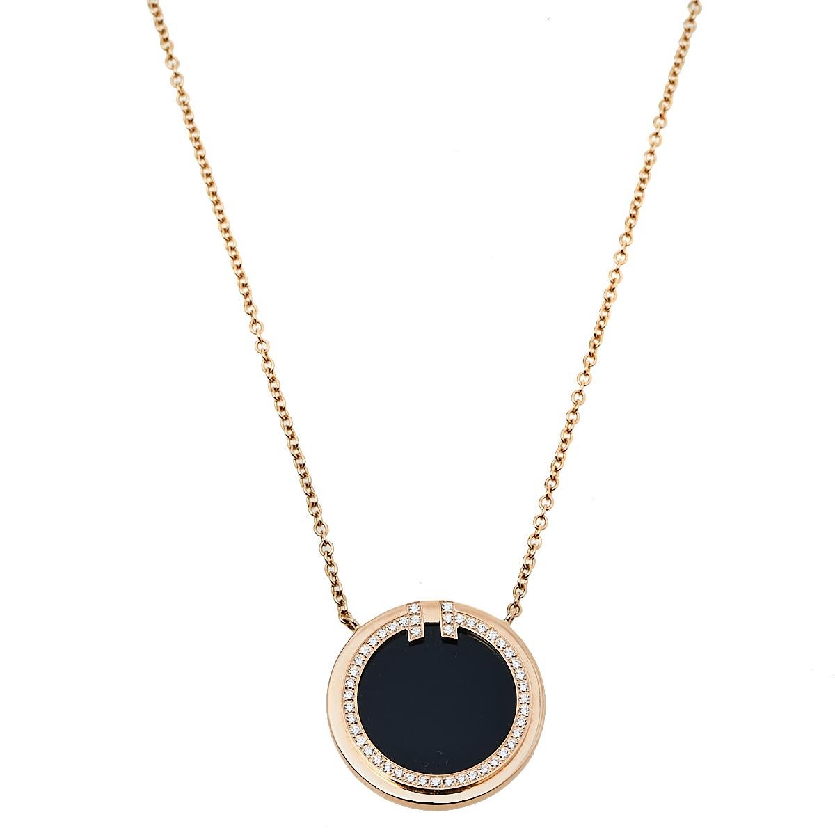 This Tiffany T necklace from Tiffany & Co. is a piece that you will always cherish wearing! Crafted from 18K rose gold, it features a slender chain carrying a circular pendant inlaid with onyx and outlined with a diamond-embellished T design. A