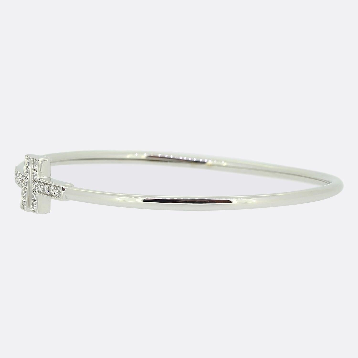 Here we have fabulous diamond bracelet from the world renowned luxury jewellery designer, Tiffany & Co. This piece forms part of the 'Tiffany T' collection and showcases a duo of diamond set 'T' motifs at the centre of the face atop a slim 18ct
