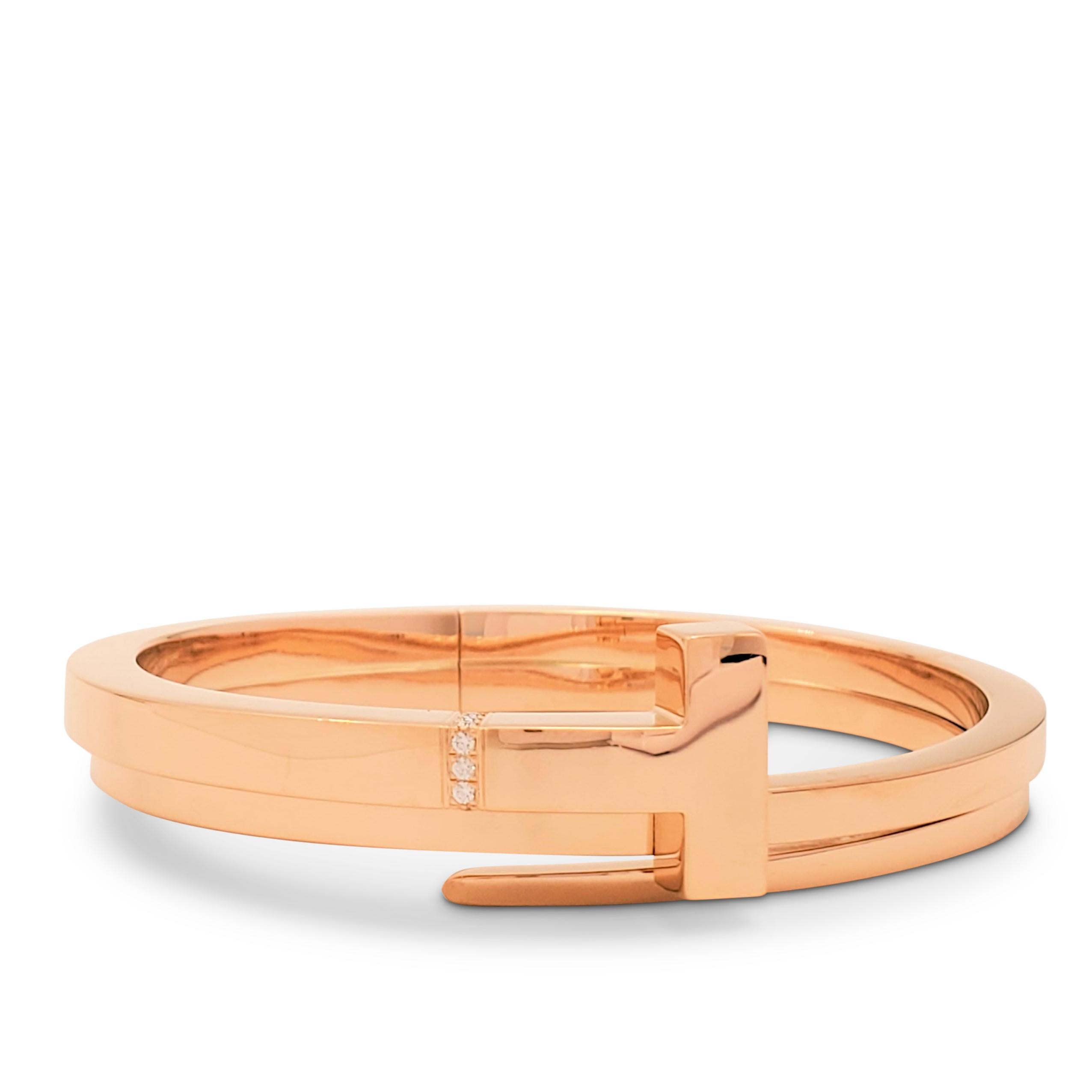 Authentic Tiffany & Co. 'Tiffany T' square wrap bracelet crafted in 18 karat rose gold and accented with an estimated 0.05 carats of high quality (E-F color, VS clarity) round brilliant cut diamonds. Signed T&Co., Au750. The bracelet is not