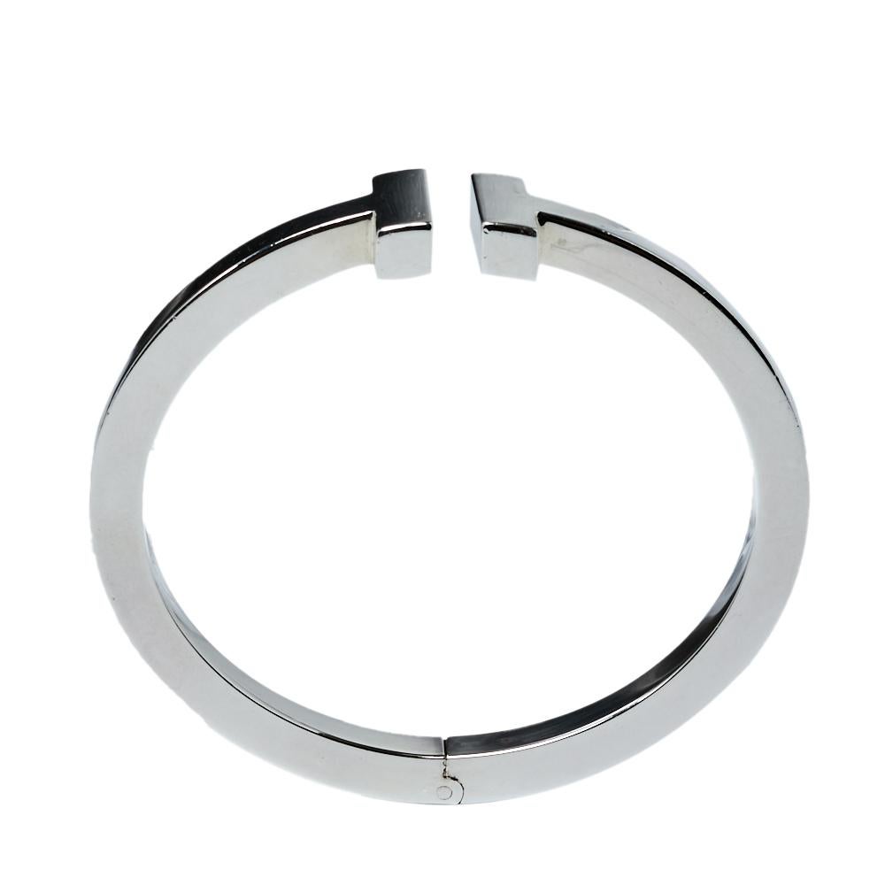 Awe-inspiring and radiating sophistication, this Tiffany T Square bracelet from Tiffany & Co. is a piece that you will always cherish wearing! Crafted from silver 925 metal, it features a smooth band that carries the letter 'T' at both ends. It has