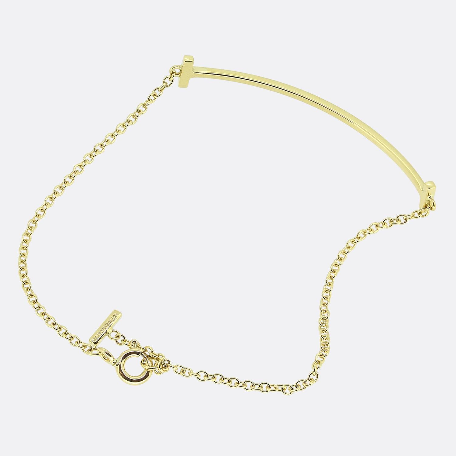 Aquí tenemos una pulsera T Smile de oro amarillo de 18 ct del mundialmente conocido diseñador de joyas de lujo Tiffany & Co.

