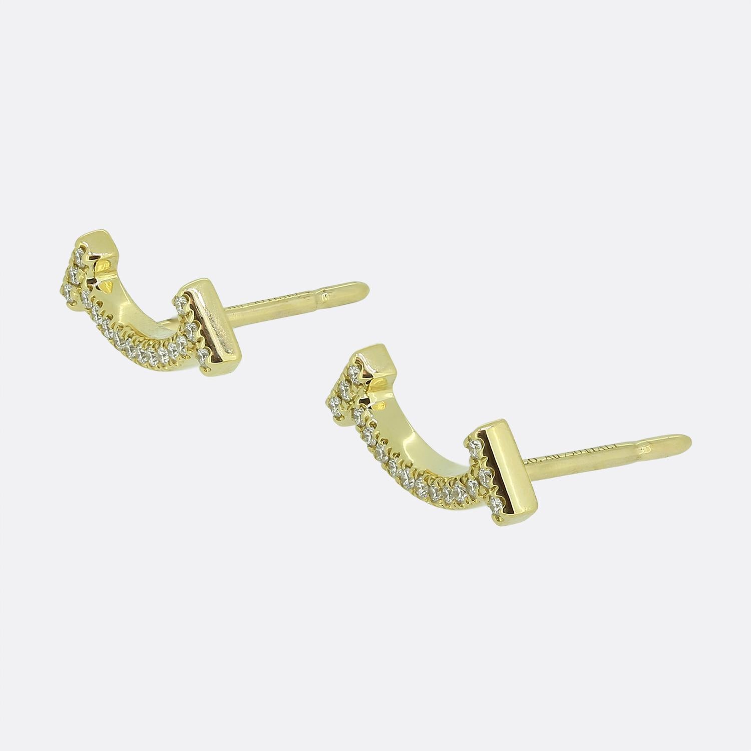 Here we have an iconic pair of Tiffany & Co. T Smile diamond earrings. The earrings have been crafted from a warm 18ct yellow gold and feature a smile motif pave set with round brilliant cut diamonds totalling approximately 0.06 carat in weight.