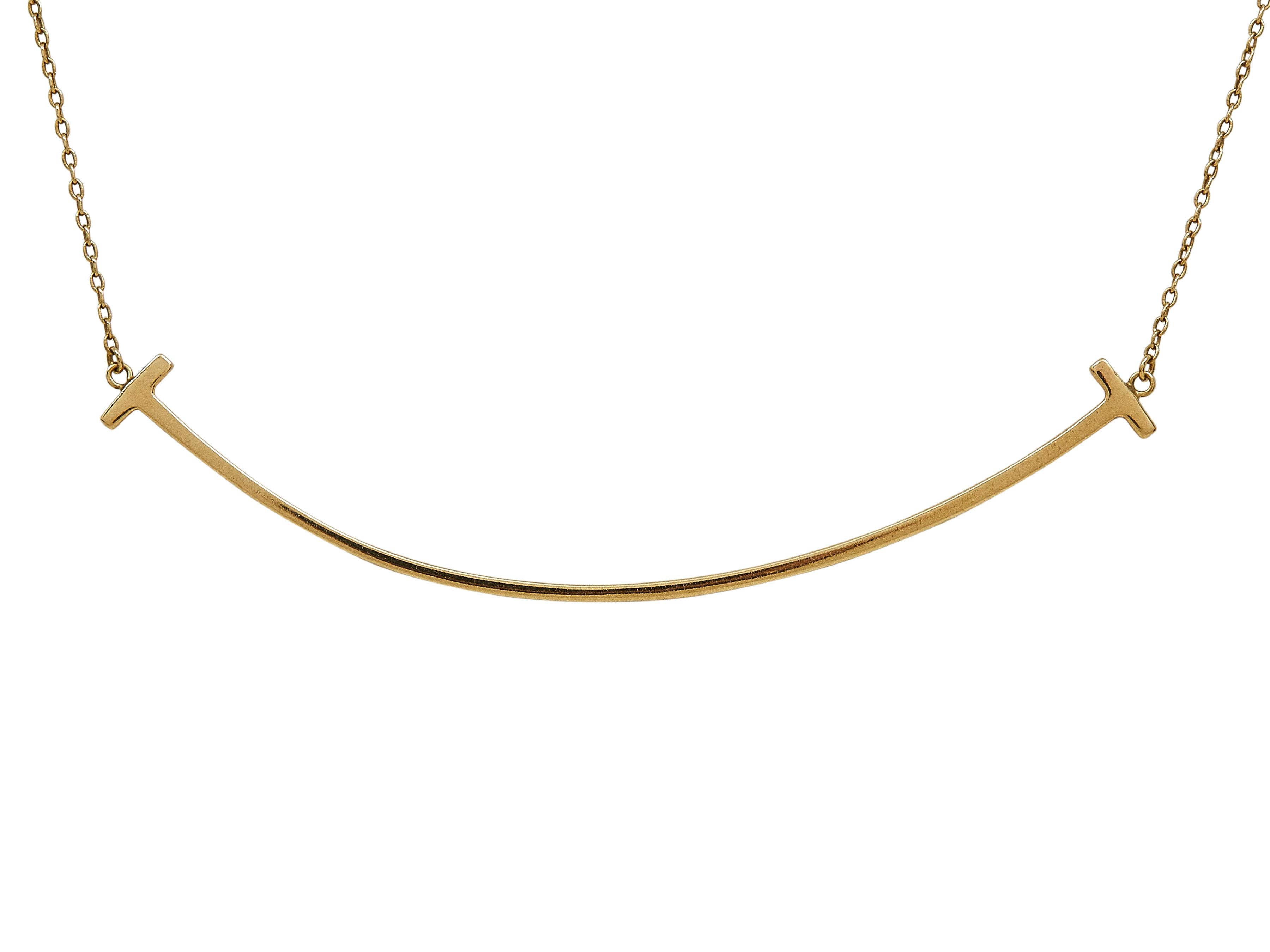 Das Armband: Ein Tiffany & Co. Tiffany T Smile Halskette mit Anhänger. Dieses große Modell ist aus achtzehn Karat Gelbgold.

Der Zustand ist sehr gut mit mäßiger Oberflächenabnutzung. Der Anhänger ist leicht verbogen.

Mehr über die Collection'S: