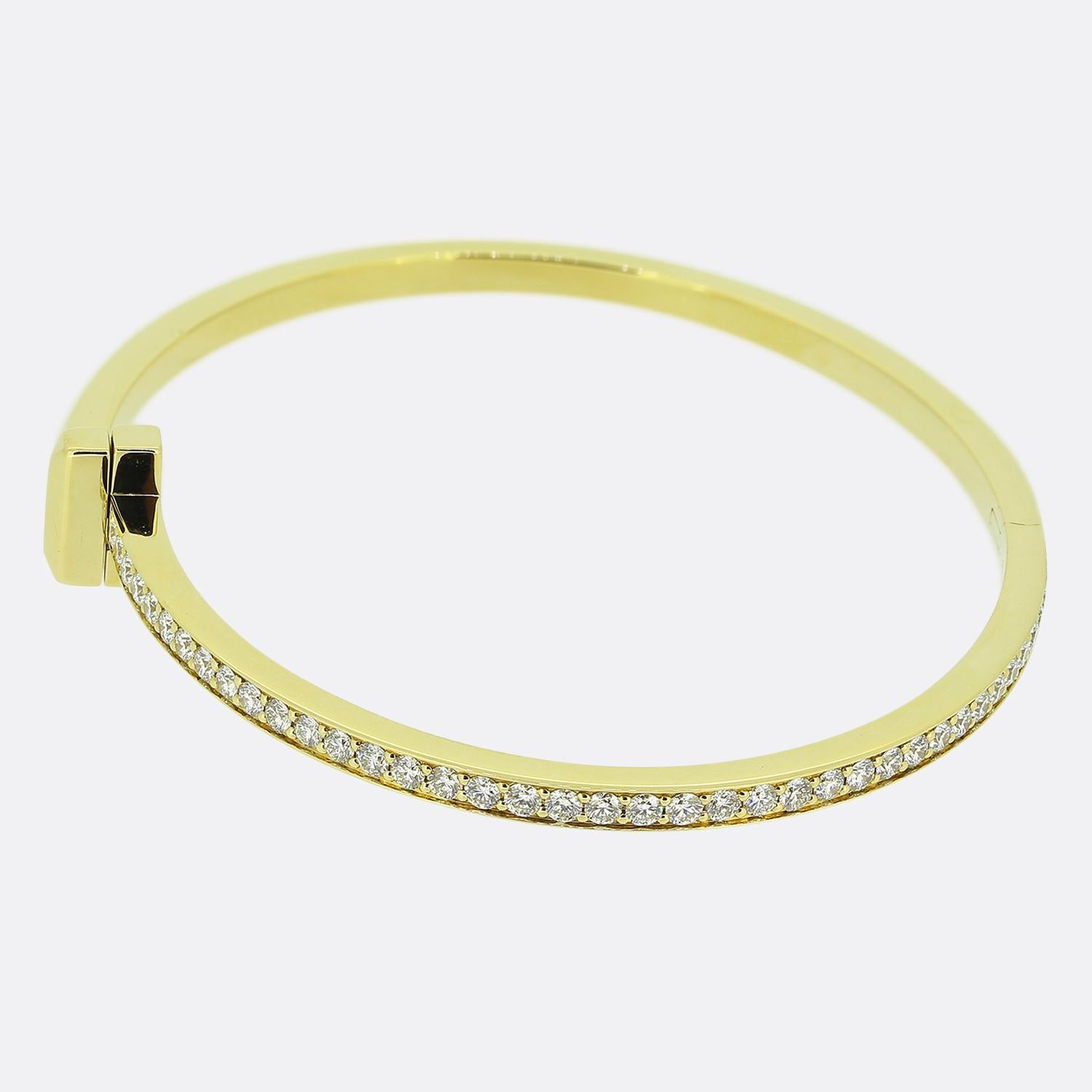 Here we have charming diamond bracelet from the world renowned luxury jewellery designer, Tiffany & Co. This 18ct yellow gold piece forms part of the 'Tiffany T' collection and showcases the iconic T motif at the centre flanked on one side by a