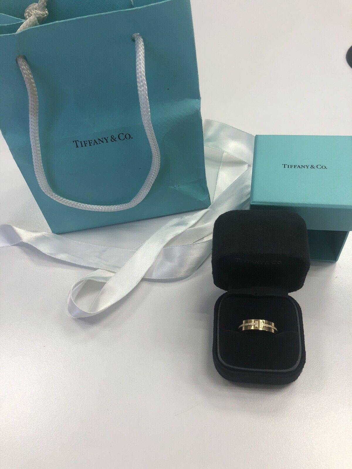 Tiffany & Co 18k Yellow Gold Round Diamond T Shaped Band
Ring Size 7.25
7.8 Grams
 White Round Brilliant Cut Diamonds 0.12 Carats Total Weight
Color: F
Clarity: VS2

This is a beautiful Tiffany & Co. diamond band that shows off these round diamonds.