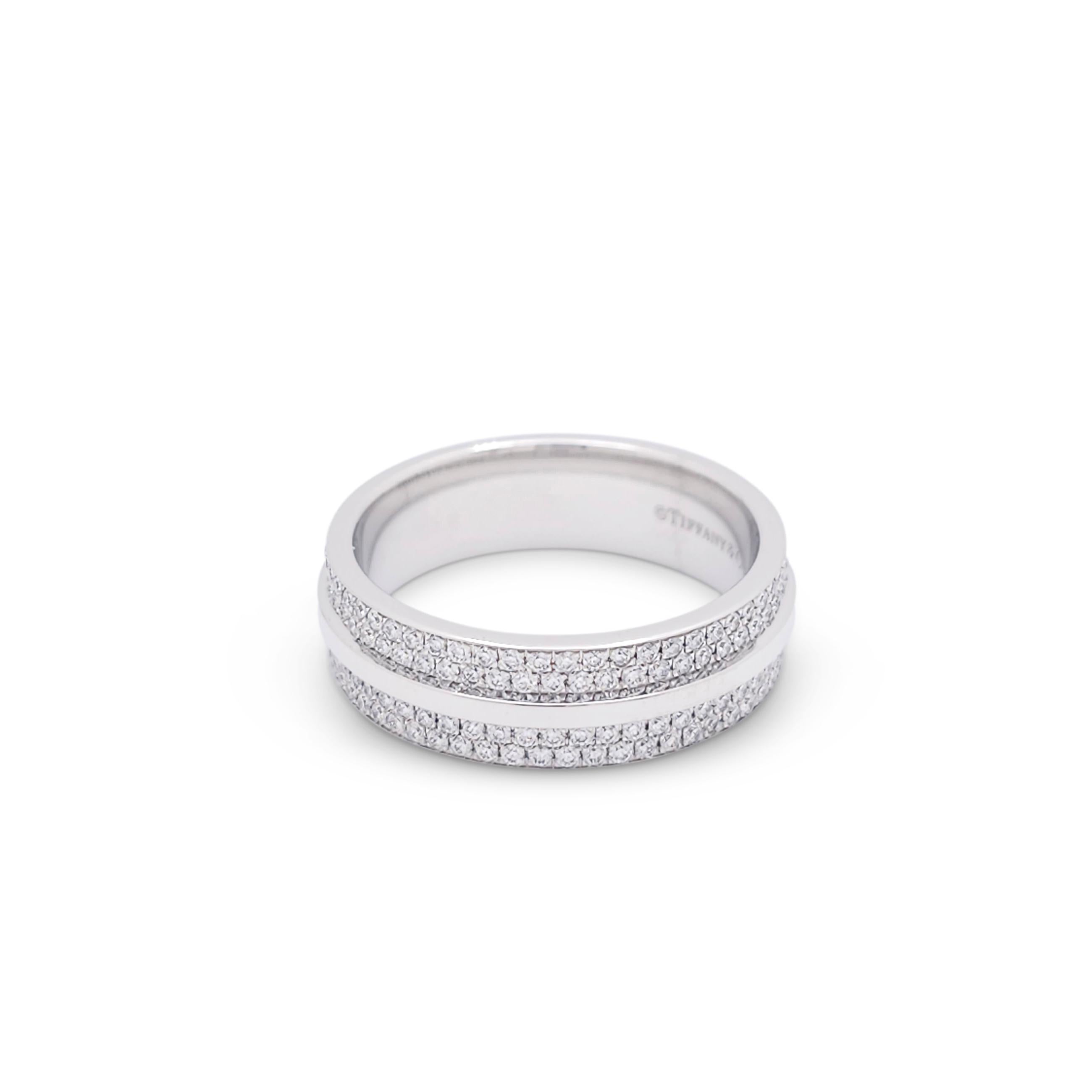 Authentic Tiffany & Co. ring from the Tiffany T collection crafted in 18 karat white gold.  The form of the letter 'T' wraps around the band and is outlined by a background of glittering pavé set diamonds weighing an estimated 0.57 carats total. 