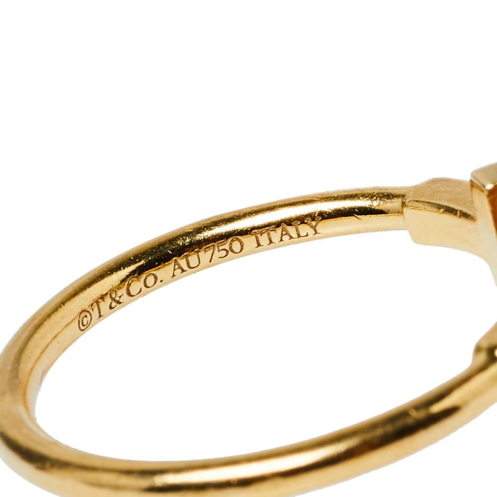 Awe-inspiring and radiating sophistication, this Tiffany T Wire ring from Tiffany & Co. is a piece that you will always cherish wearing! Crafted from 18K yellow gold, it features a wire-like band that carries the letter 'T' at both ends. It has the