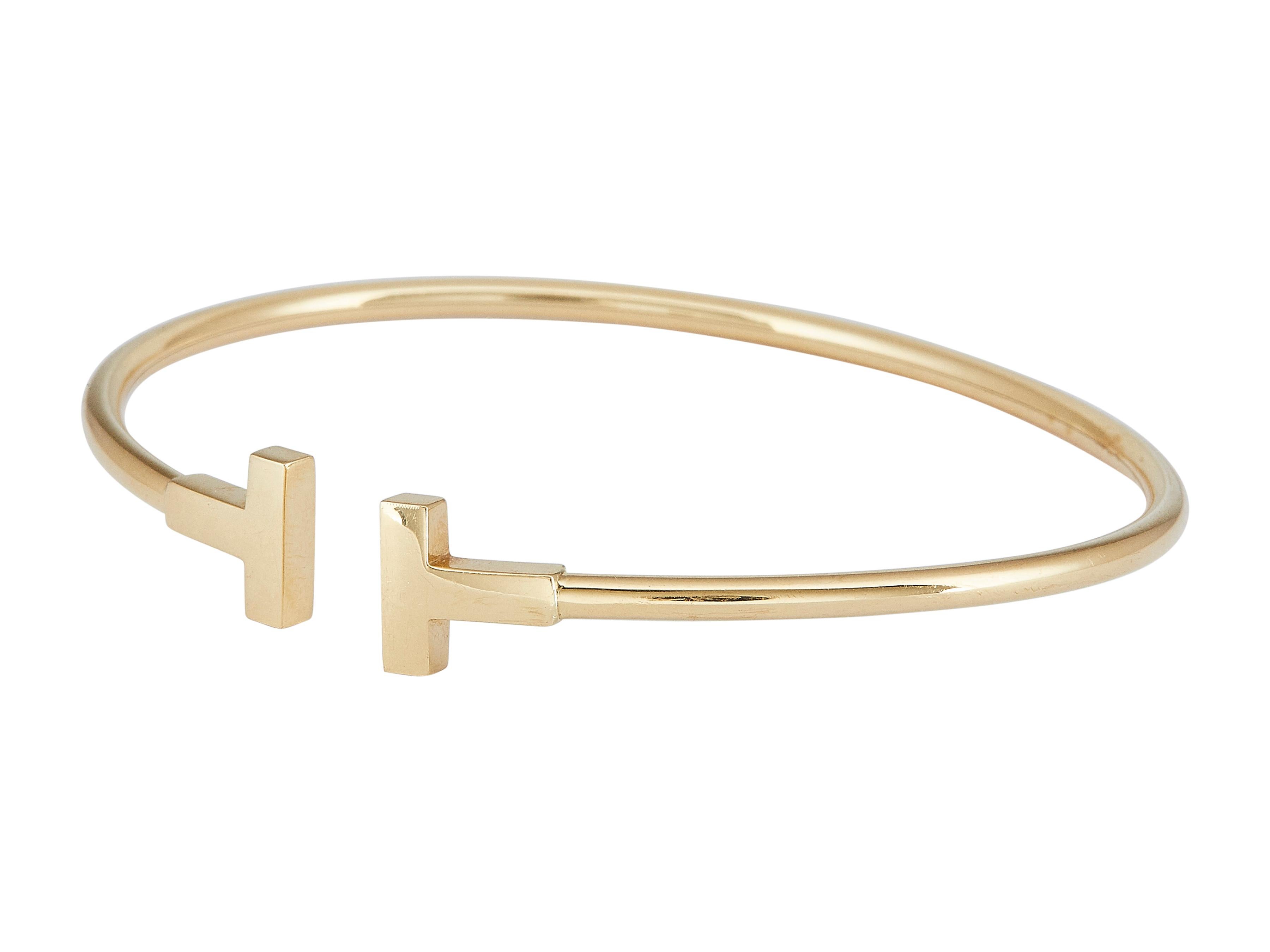Das Armband: Ein Tiffany & Co. Tiffany T Wire Manschettenarmband aus achtzehnkarätigem Gelbgold. Als flexibler Draht konzipiert, der in einem Paar polierter Gold-Ts endet.

Das Armband ist in gutem Zustand. Leicht unrund.

Mehr über die