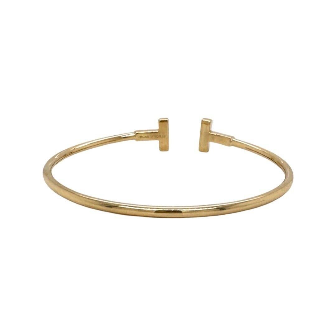 Designer: Tiffany & Co.

Collection: Tiffany T 

Style: Bangle/ Bracelet 

Metal: Yellow Gold 

Stones: 18 Round Brilliant Diamonds 

Metal Purity: 18k - 750

Wrist Size:  up to 6.25

Total CaratWeight (grams): 0.22

​​​​​​​Total Item Weight