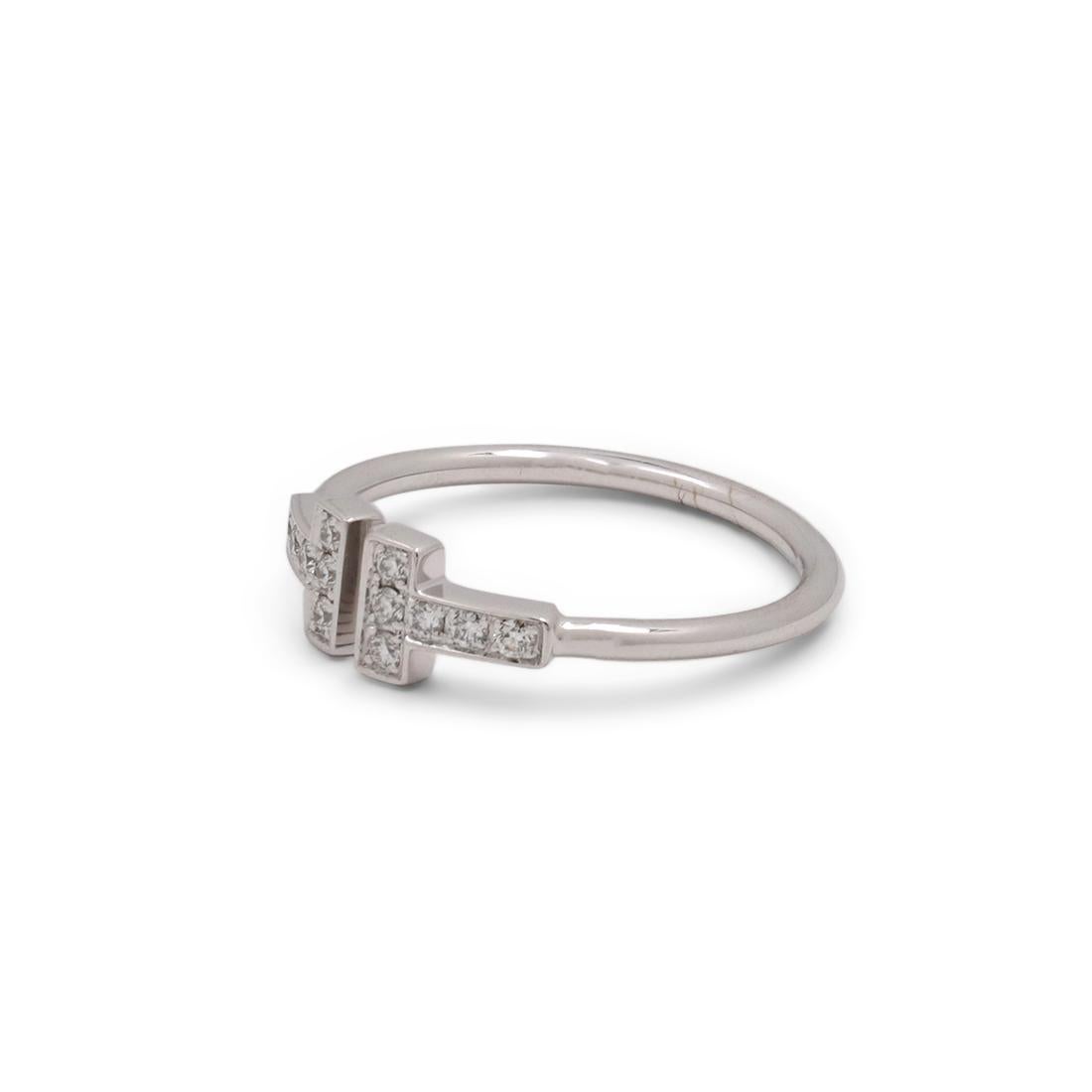 Authentic Tiffany & Co. 'Tiffany T Wire' ring crafted in 18 karat white gold and accented with an estimated 0.13 carts of high quality (G/H color, VS clarity) round brilliant cut diamonds. This stunning ring features a bold 