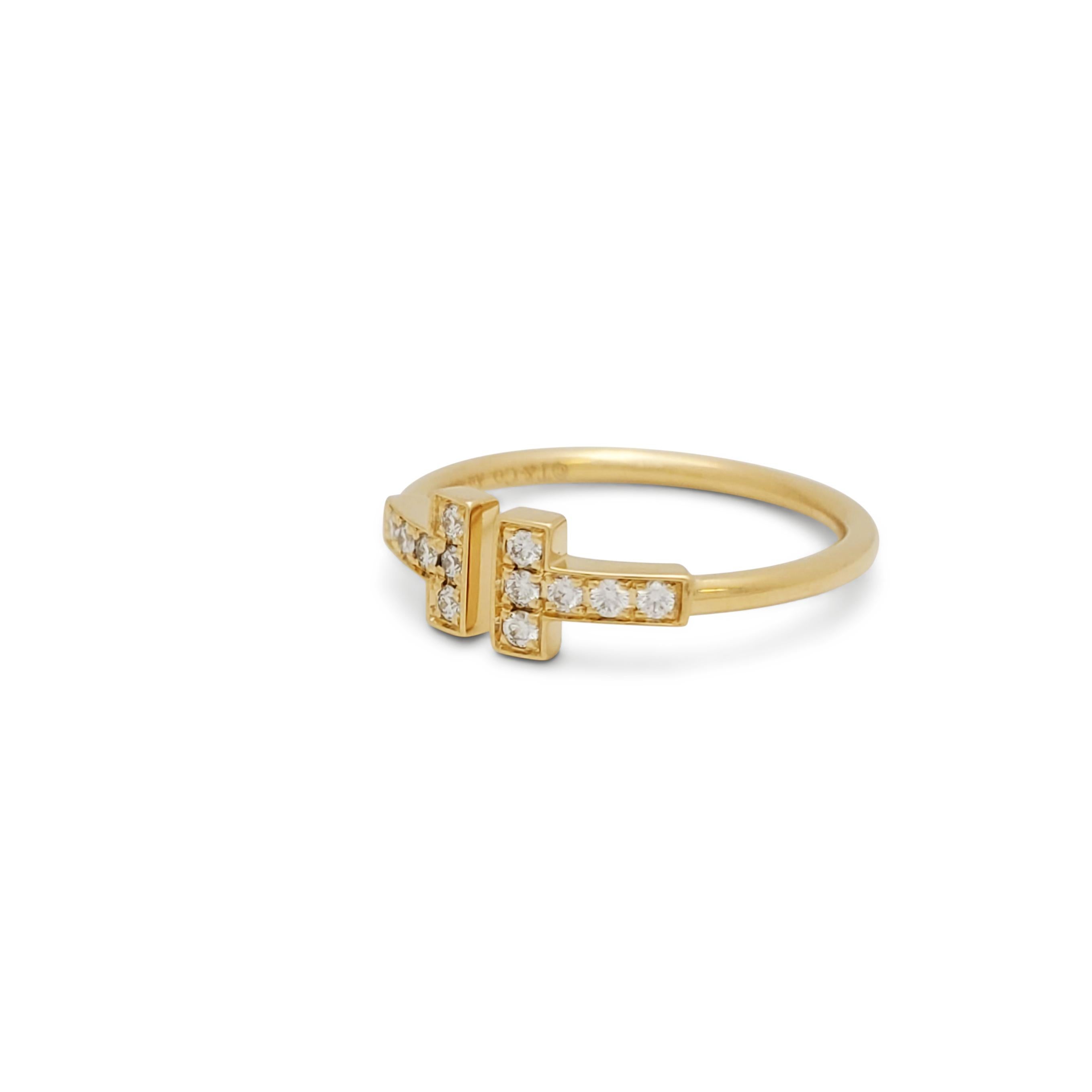 Authentic Tiffany & Co wire ring from the Tiffany T collection crafted in 18k Yellow Gold.  The bold T motif at the center of the ring is set with approximately 0.18 carats of round brilliant cut diamonds. Signed T&Co., AU750. Ring size 5 1/2 US. 