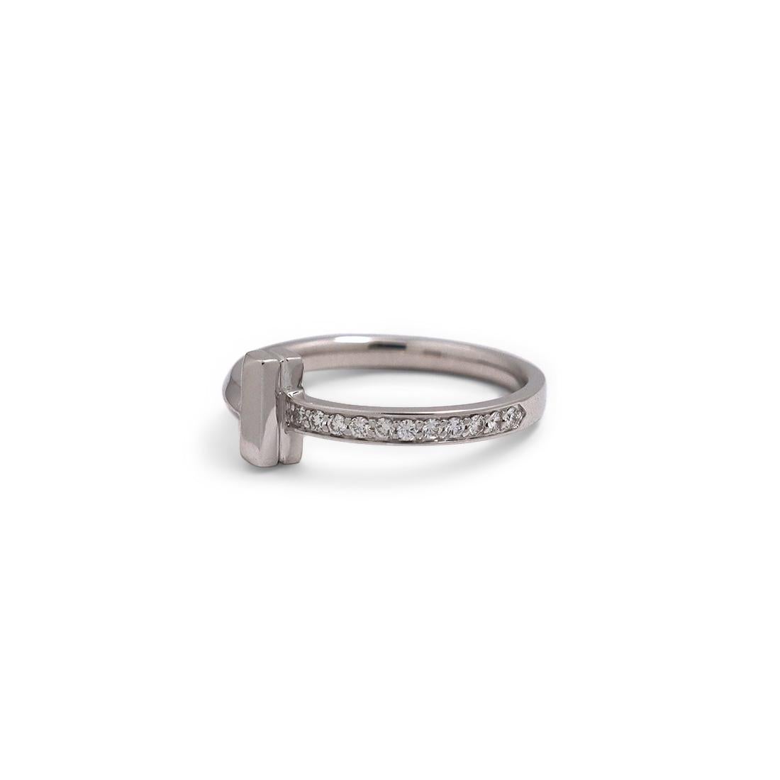 Authentic Tiffany & Co. 'Tiffany T1' ring crafted in 18 karat white gold. The bold 'T' design is accented with an estimated 0.09 carats of high quality pave diamonds. Signed T&Co., AU750, ITALY. Ring size 6 1/2 US, 53 EU. The ring is presented with