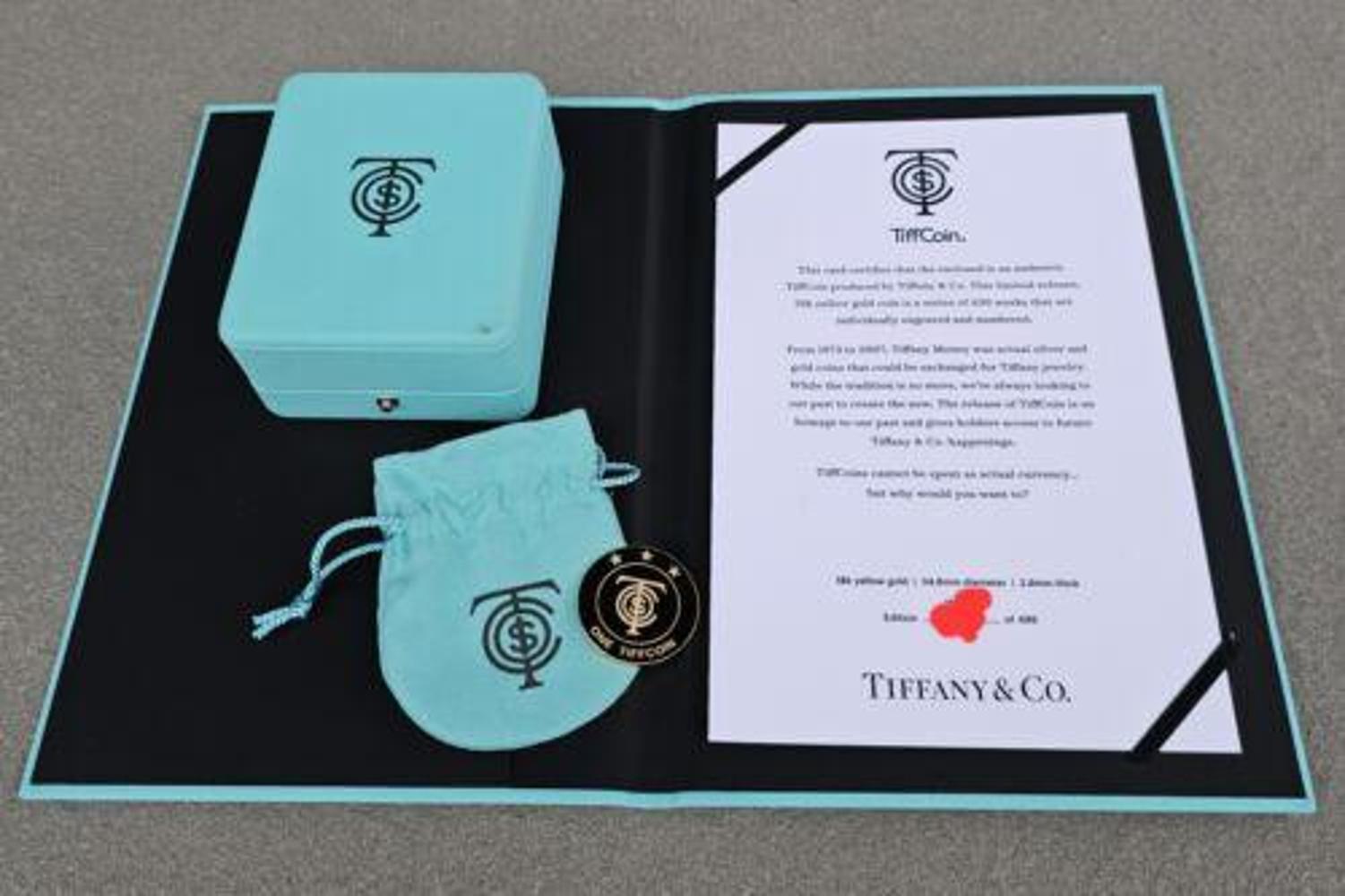 Diese exquisite Tiffany & Co. Die Tiffcoin ist eine Rarität, die in einer Auflage von nur 499 Stück hergestellt wurde. Diese aus 18 Karat Gelbgold gefertigte Sammlermünze ist ein echtes Zeugnis der unvergleichlichen Handwerkskunst der Marke. Das