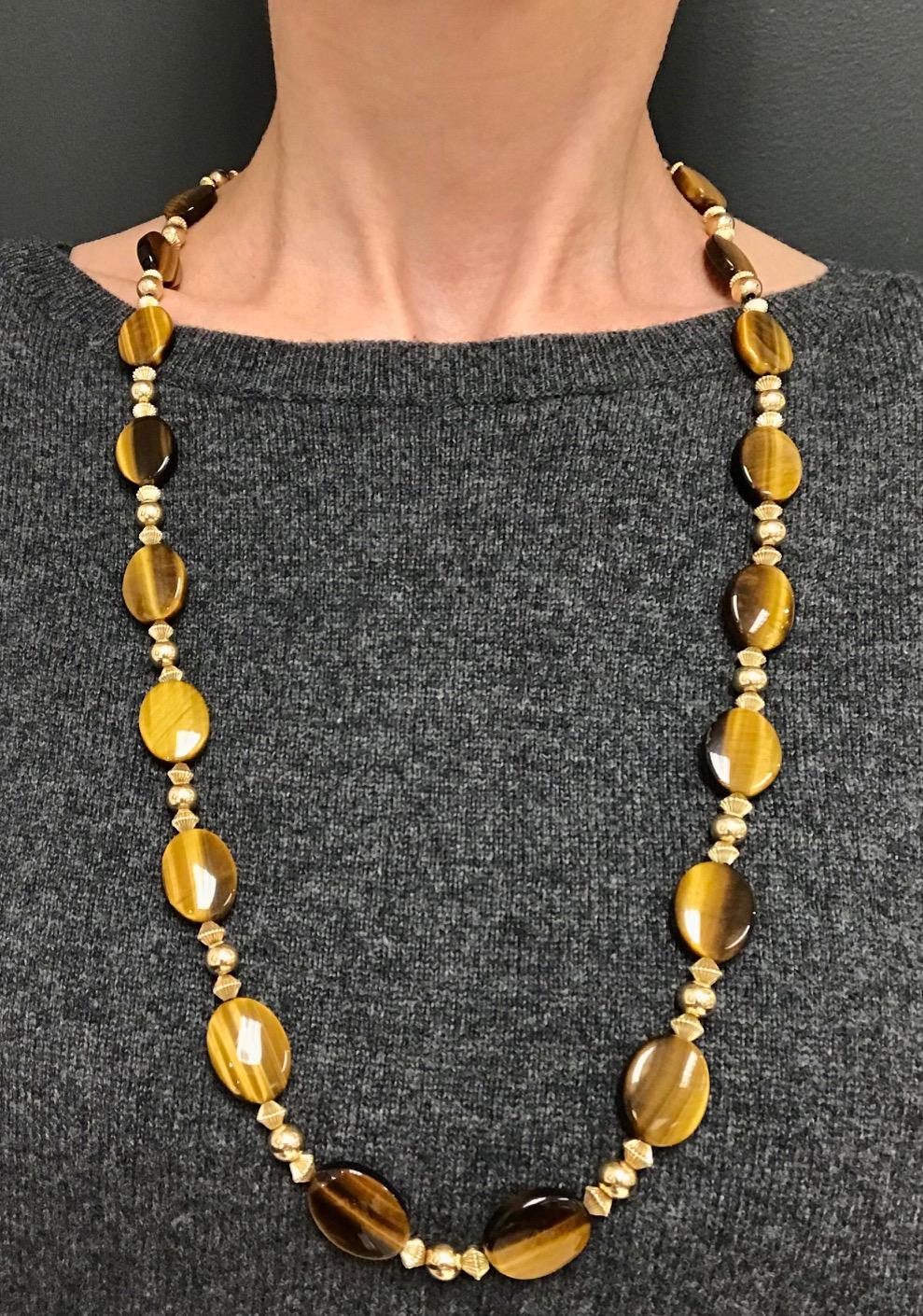 A gorgeous 14k gold and tiger's eye necklace by Tiffany & Co.
The gold rhombus and beads alternate with the oval tiger's eye disks. The gems are high-polished which creates an amazing glossy, silky look. This Tiffany & Co. necklace is beautifully