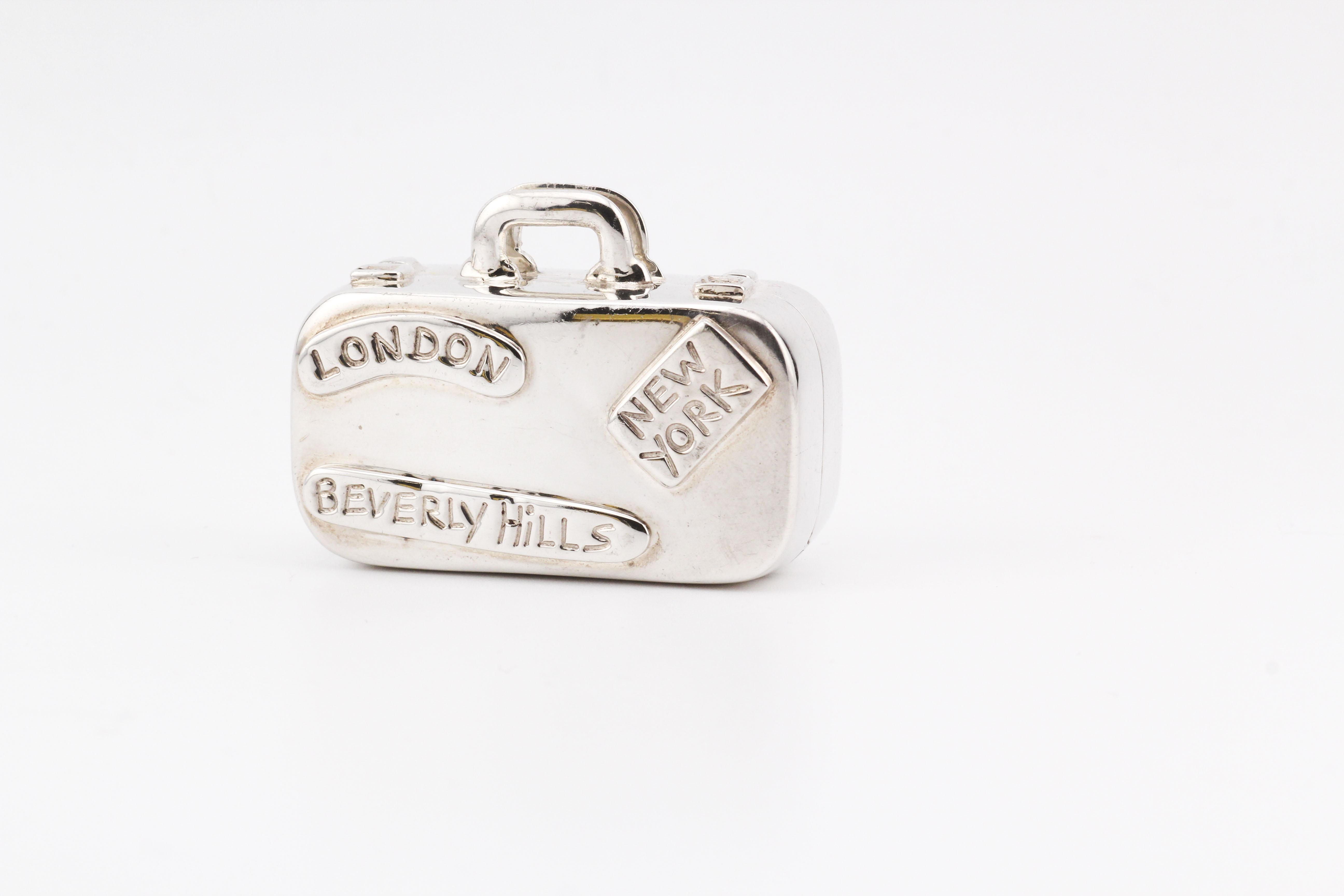 The Tiffany & Co. Sterling Silver Suitcase Pill Box is a charming nod to the world of travel and adventure. Crafted with precision, this miniature suitcase is made from lustrous sterling silver, showcasing the brand's commitment to quality and