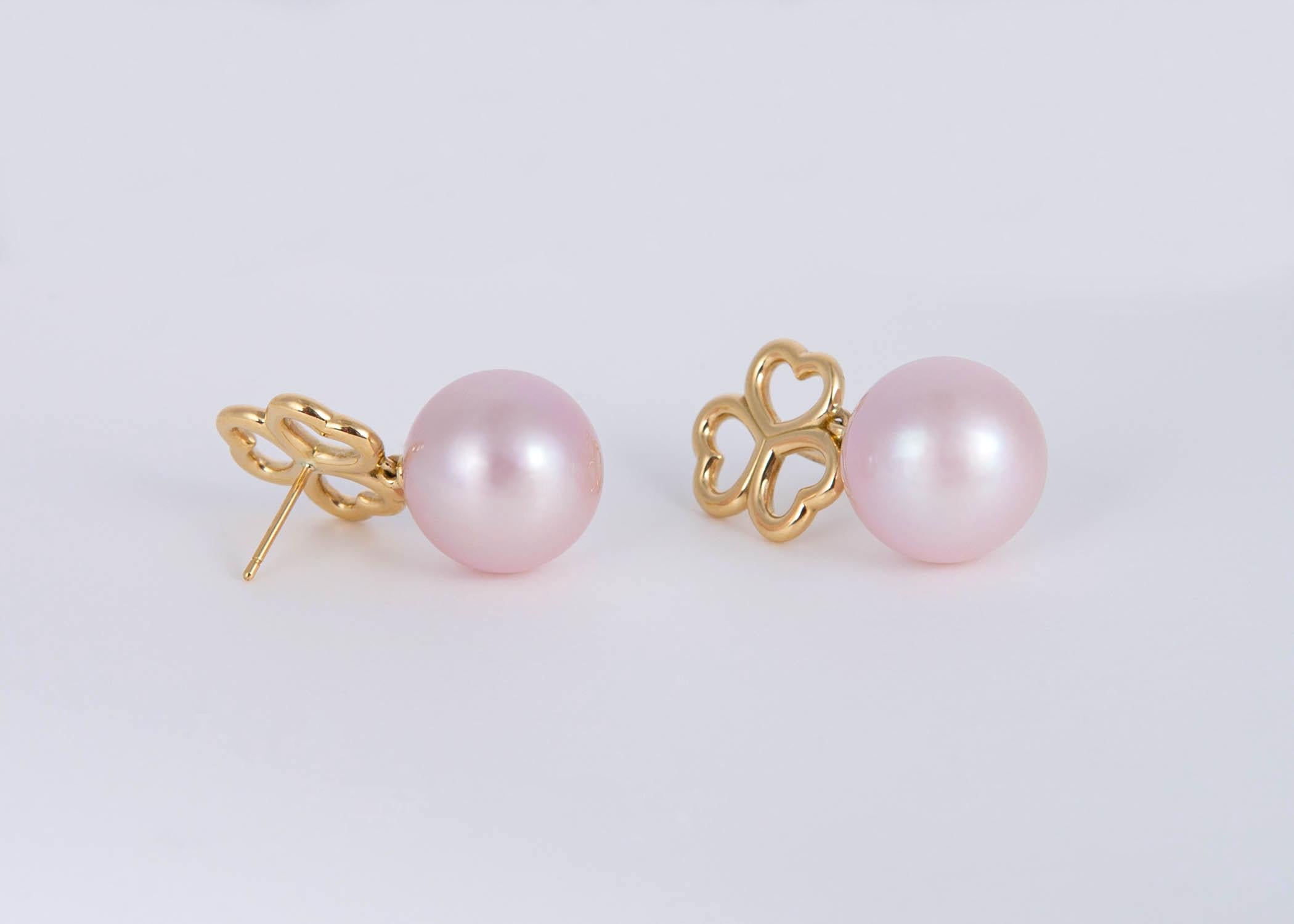 A classic three heart gold top and 13.7 mm pastel pink fresh water pearls combine to make a beautiful classic wearable earring. Tiffany quality and design. Just over 1 inch in length. 