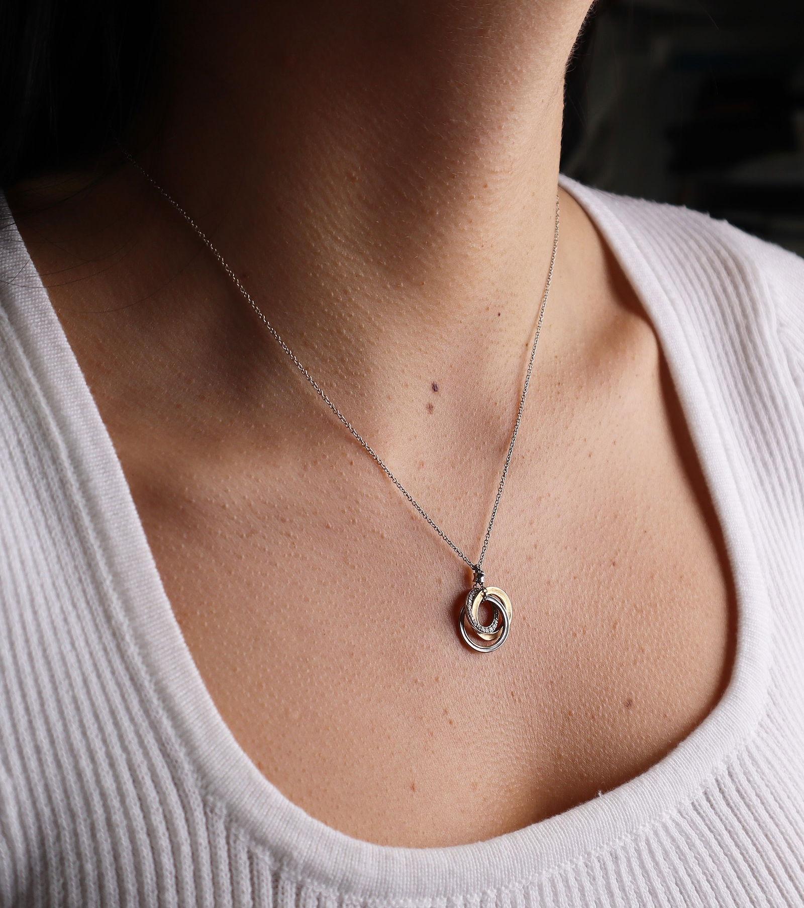 Este elegante collar Tiffany & Co. está fabricado por expertos en oro rosa y blanco de 18 quilates, y presenta tres círculos entrelazados que simbolizan la unidad y la conexión duradera. Un círculo está bellamente acentuado con radiantes diamantes