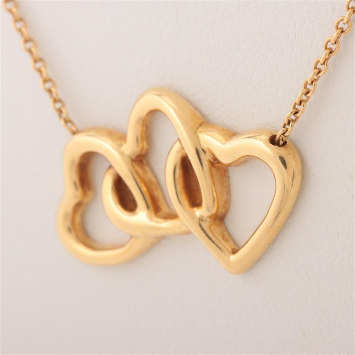 The Tiffany & Co. Triple Interlocking Open Heart Pendant Necklace in Gold is a symbol of elegance and love. The exquisite necklace features three open heart-shaped pendants interlocked with each other. Each heart pendant is meticulously crafted from