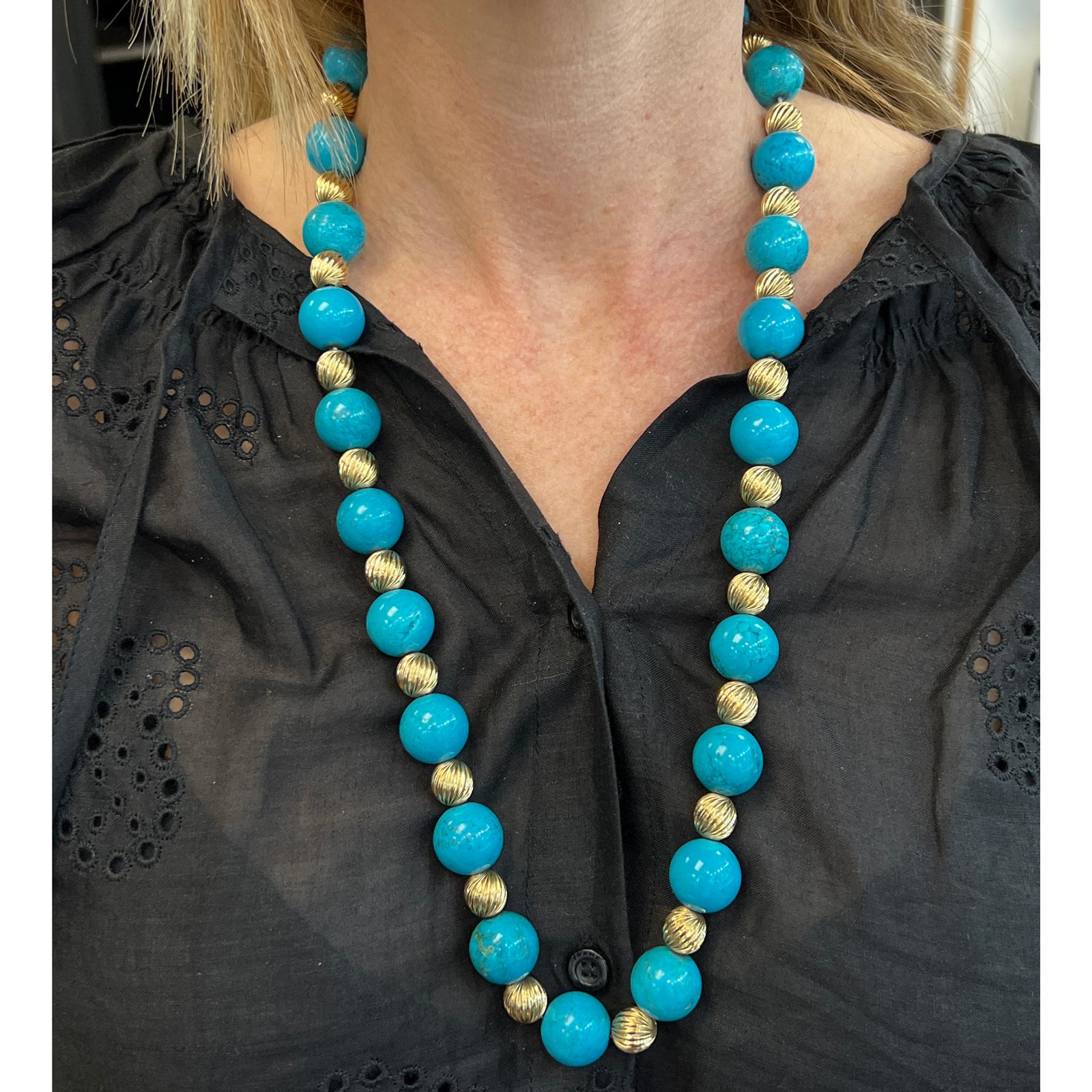 Fabulous turquoise and 14 karat yellow gold bead necklace desgined by Tiffany & Co. The necklace features 16mm natural turquoise beads alternating with gold balls. The necklace measures 26 inches in length, and features Tiffany's signature X gold