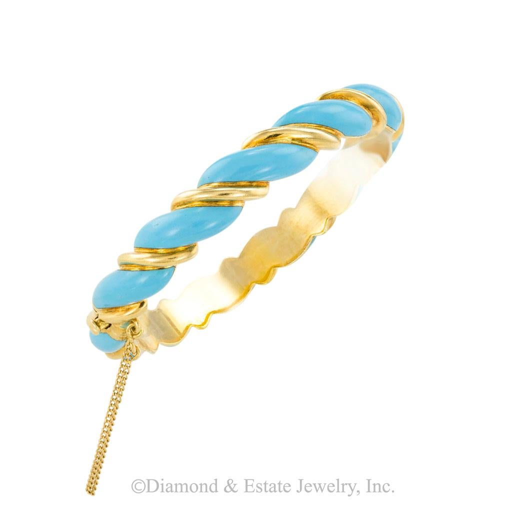 Tiffany & Co turquoise enamel and yellow gold hinged bangle bracelet circa 1970.  

SPECIFICATIONS:

METAL:  eighteen karat yellow gold decorated by turquoise color enamel.

WEIGHT:  39.7 grams.

BRACELET CLASP:  plunger clasp with fixed safety