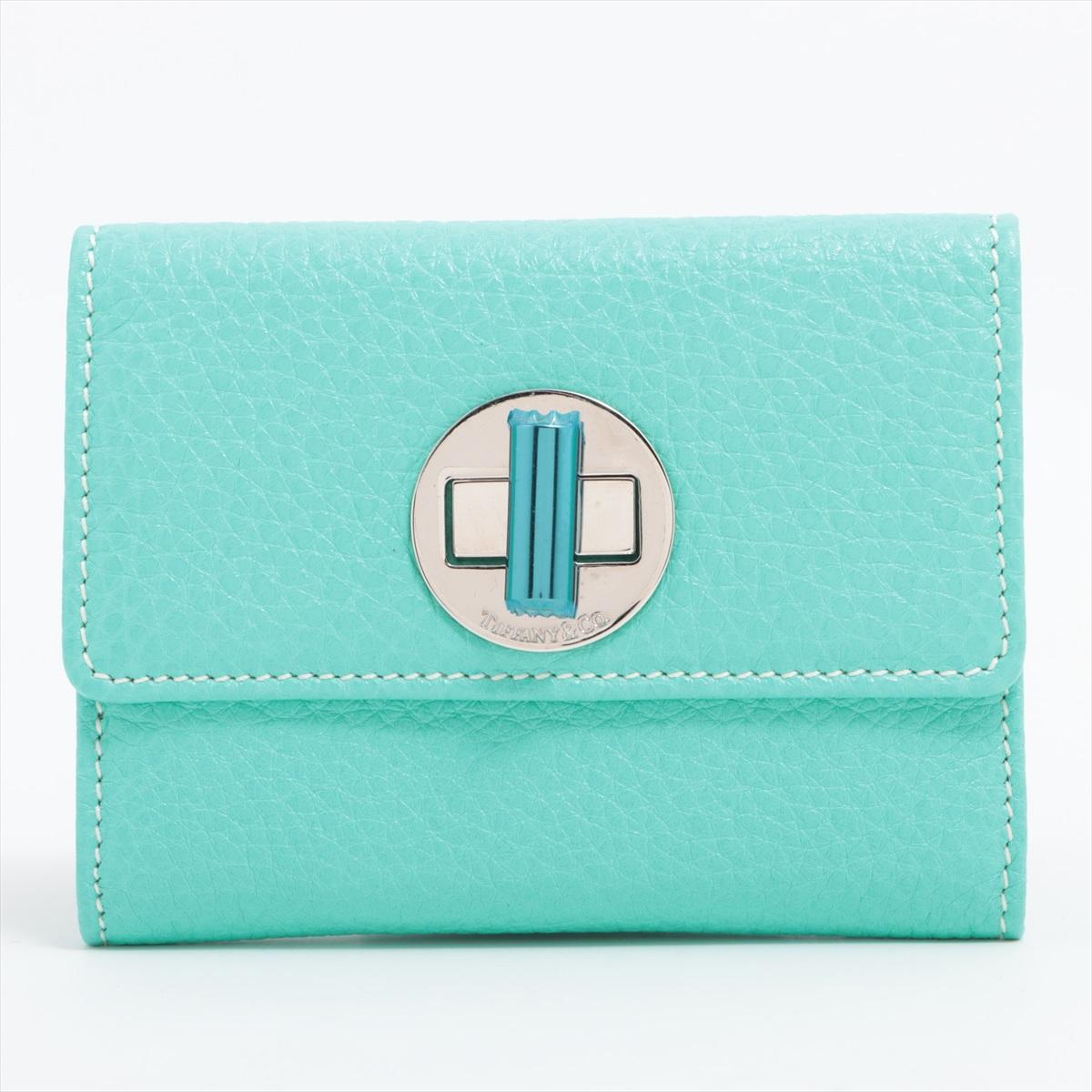The Tiffany & Co Twist-lock Leather Coin Purse in Blue is a refined and compact accessory that seamlessly blends luxury with practicality. Crafted from smooth leather, the coin purse features a sophisticated twist-lock closure adorned with the