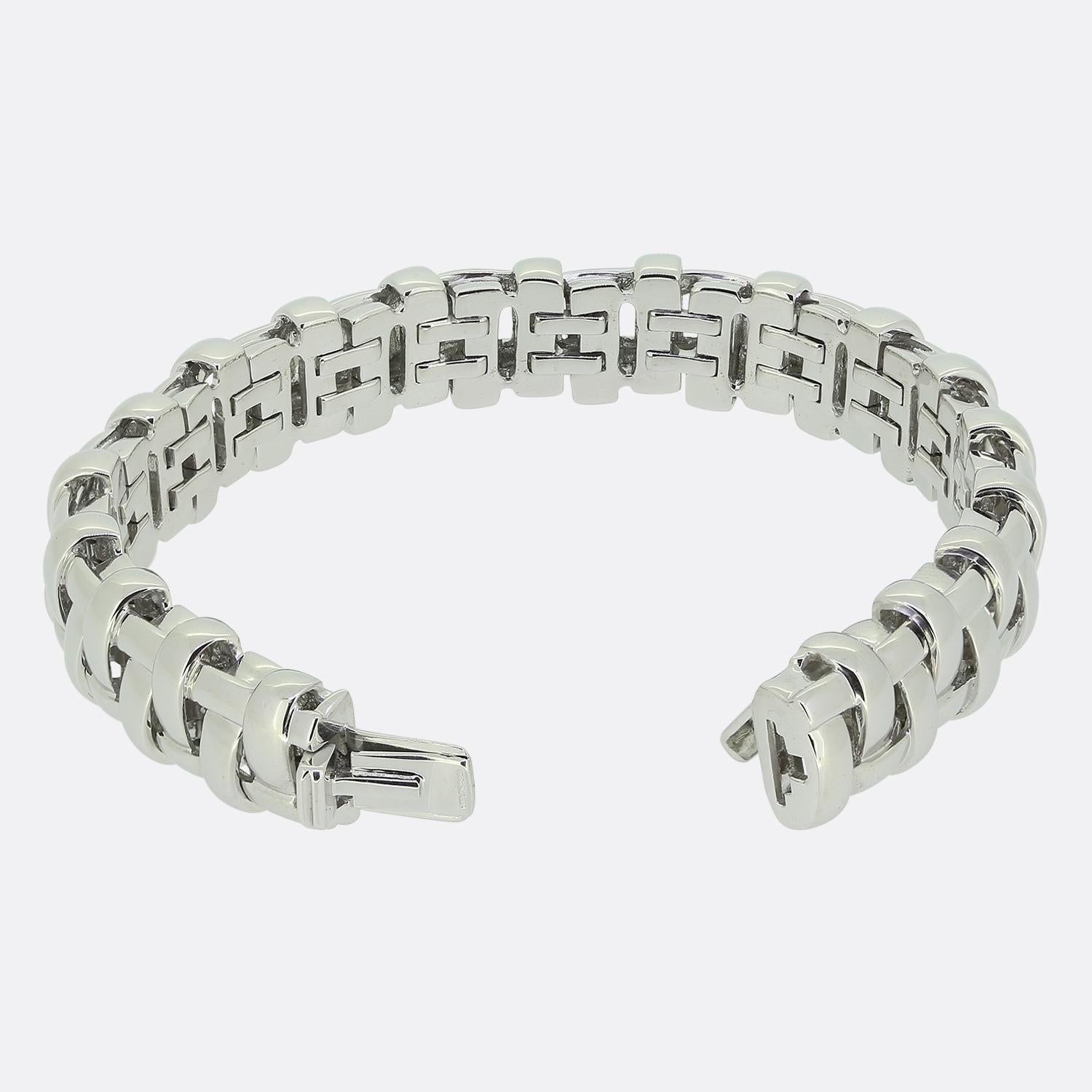Aquí tenemos una distinguida creación del mundialmente conocido diseñador de joyas Tiffany & Co. Esta pulsera está fabricada en oro blanco de 18 quilates y presenta un diseño de eslabones entrelazados que recuerda a una celosía. La estructura de la